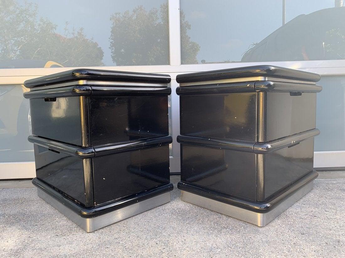 Beautiful pair of nightstands designed by Jay Spectre in the late 1970s or early 1980s. The nightstands are freshly refinished in a high gloss black lacquered finish, the plinth base is embossed with brushed chrome, they each have two large drawers