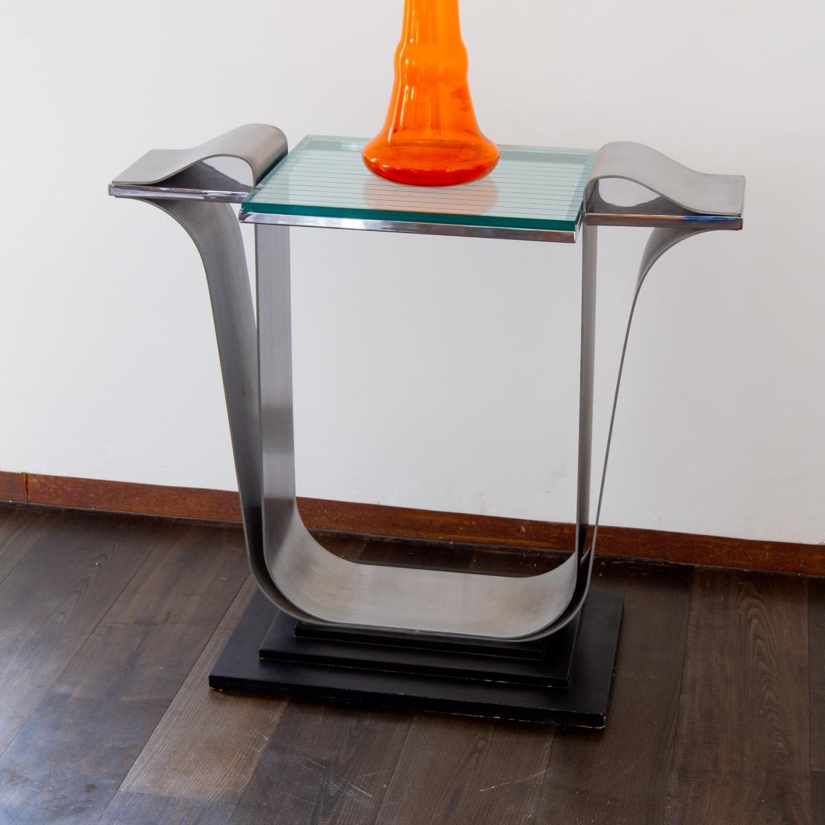 A Jay Spectre designed brushed and polished steel console table with linear etched glass top on a stepped ebonised base, 1980s.

Jay Spectre (1929-1992) was a New York based interior and furniture designer. He set up Jay Spectre Inc in 1968 which