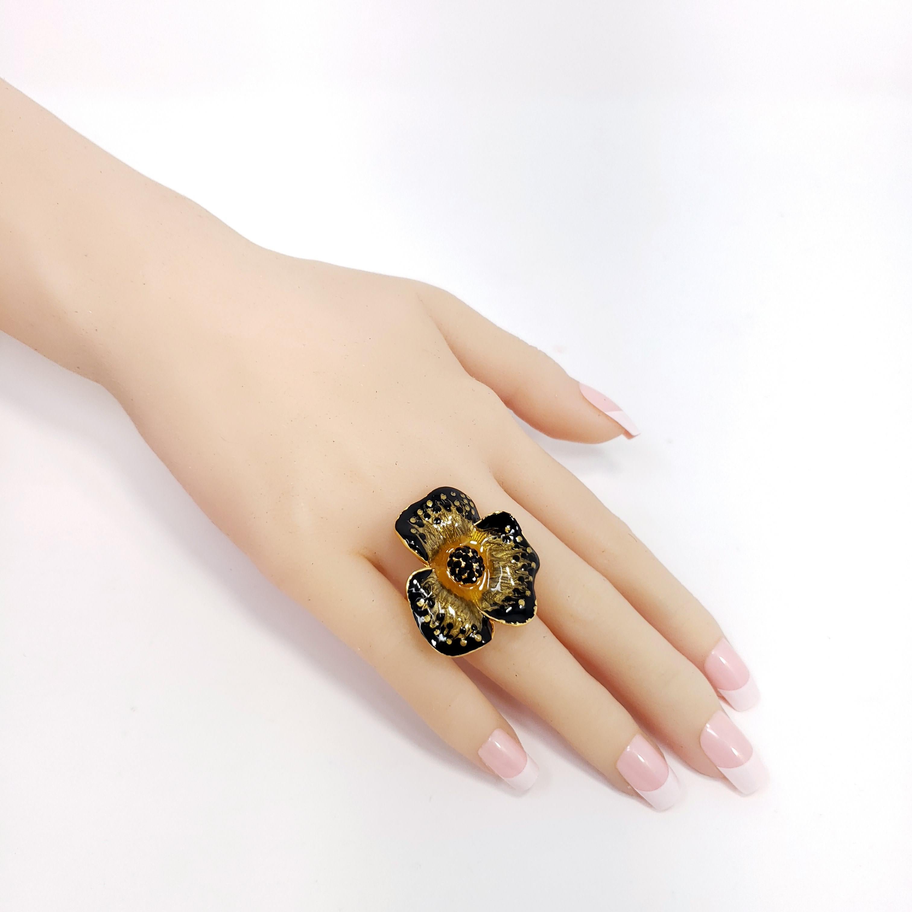 Flower power! An ornate floral statement ring featuring a blooming flower painted black and yellow enamel and accented with jet-black crystals. Set on gold plated metal.

Ring size US 8.5

Hallmarks: Jay, Jay Strongwater, CN

By Jay Strongwater,
