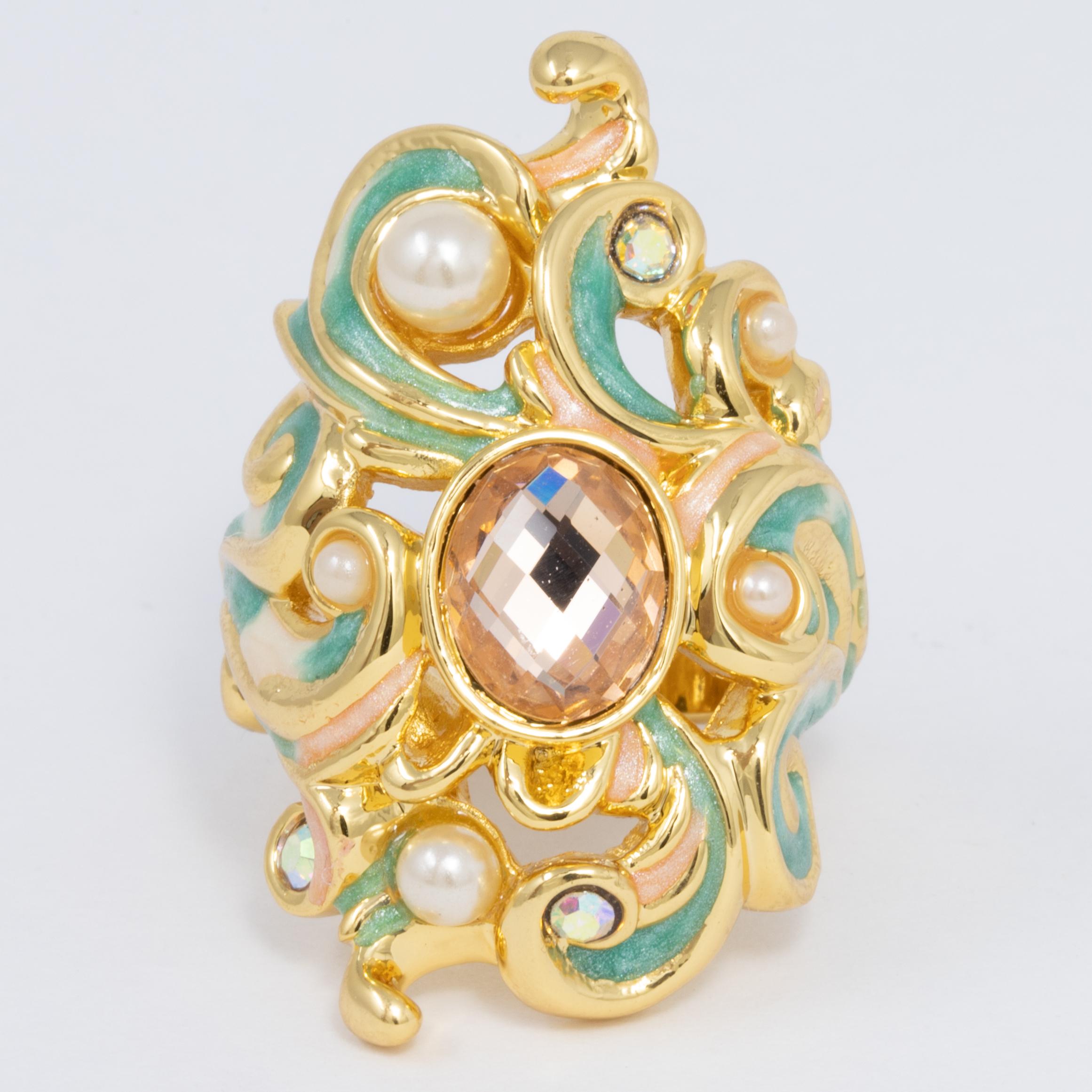 A colorful statement ring straight out of a fairy tale! This stylish accessory features a magical scroll design, painted in green enamel and accented with faux pearls and crystals.

Ring size US 7.5

Hallmarks: Jay, Jay Strongwater, CN

By Jay