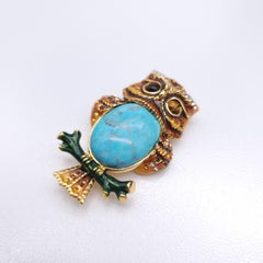 Broche búho Jay Strongwater con turquesa y esmalte en tono dorado, ojos de ámbar