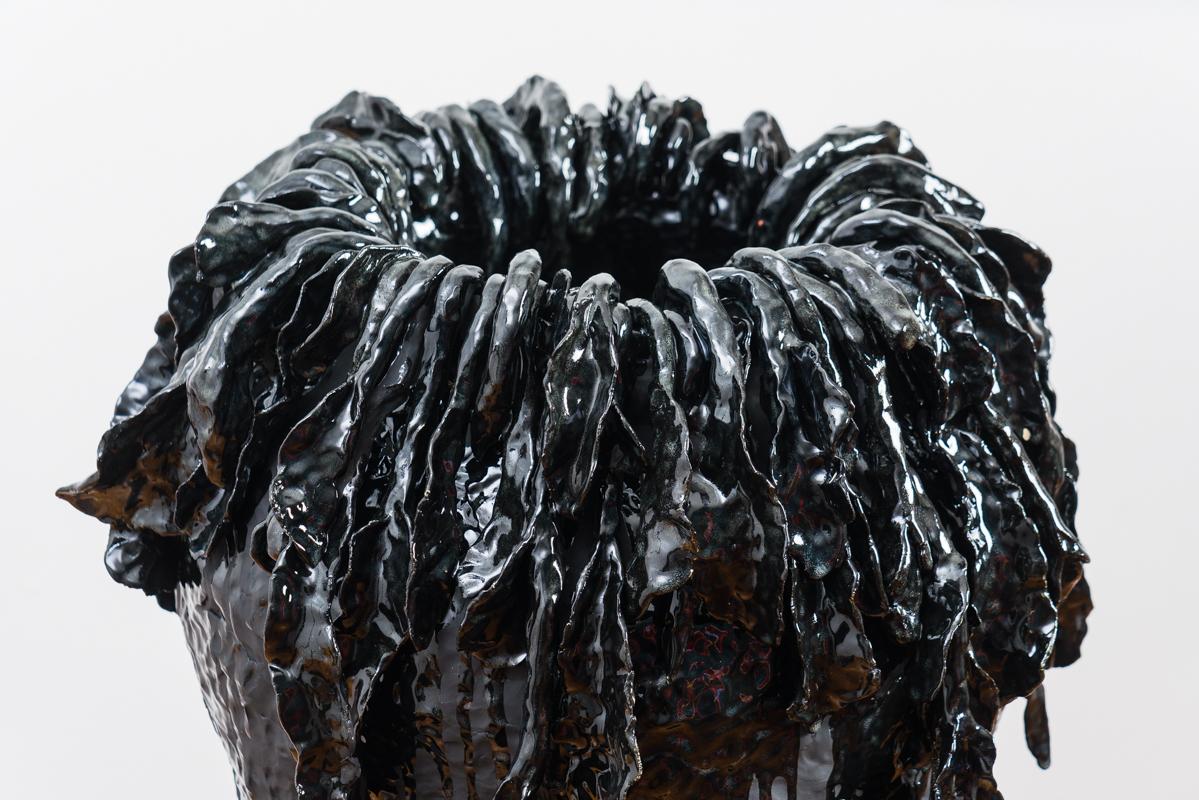 Este jarrón de cerámica esmaltada negra, único en su especie y de gran tamaño, está hecho a mano por la artista coreana-estadounidense Jaye Kim. Esta singular vasija de gran tamaño tiene un acabado brillante y mate que contrasta a la perfección en