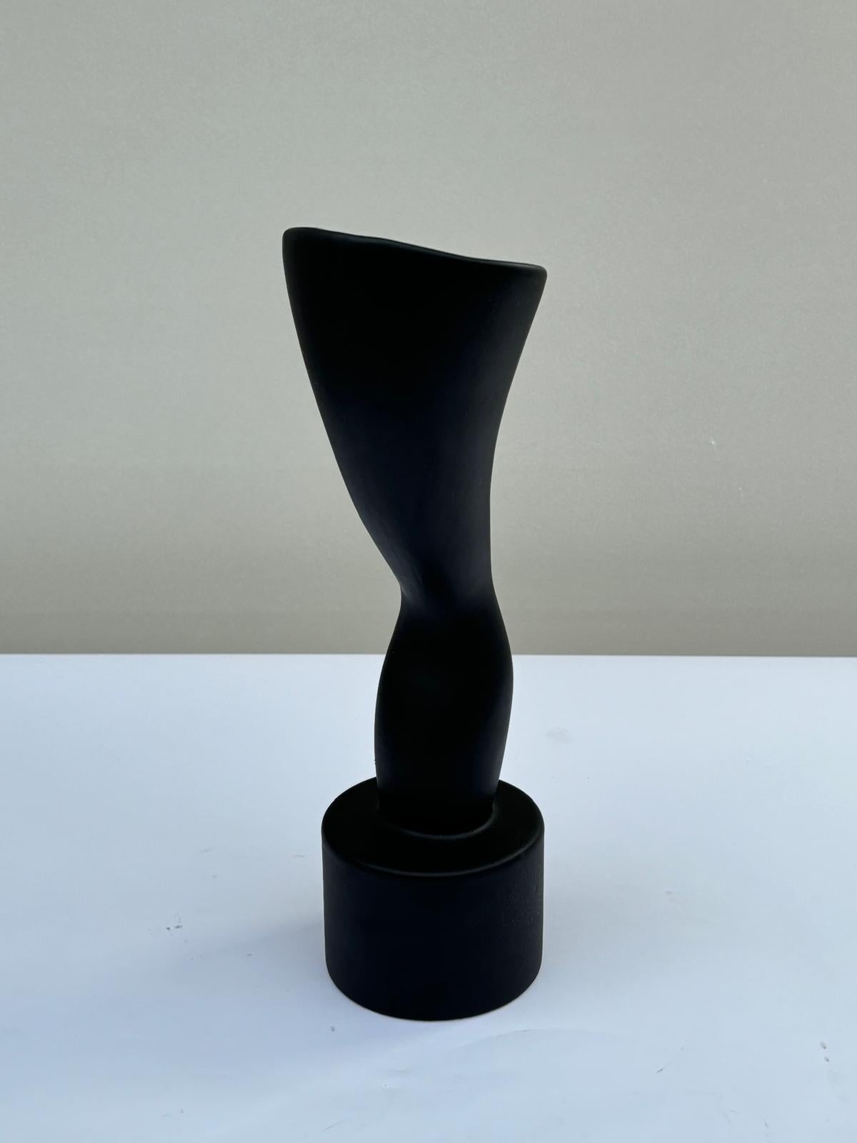 Vaso Tromba disegnato da Ambrogio Pozzi e prodotto da Ceramiche Rometti Umbertide nel 2006. Firmato.
Il vaso in maiolica, rivestito di smalto nero opaco, fa parte della serie Jazz, formata da tre vasi che, attraverso linee sinuose e zigzaganti,