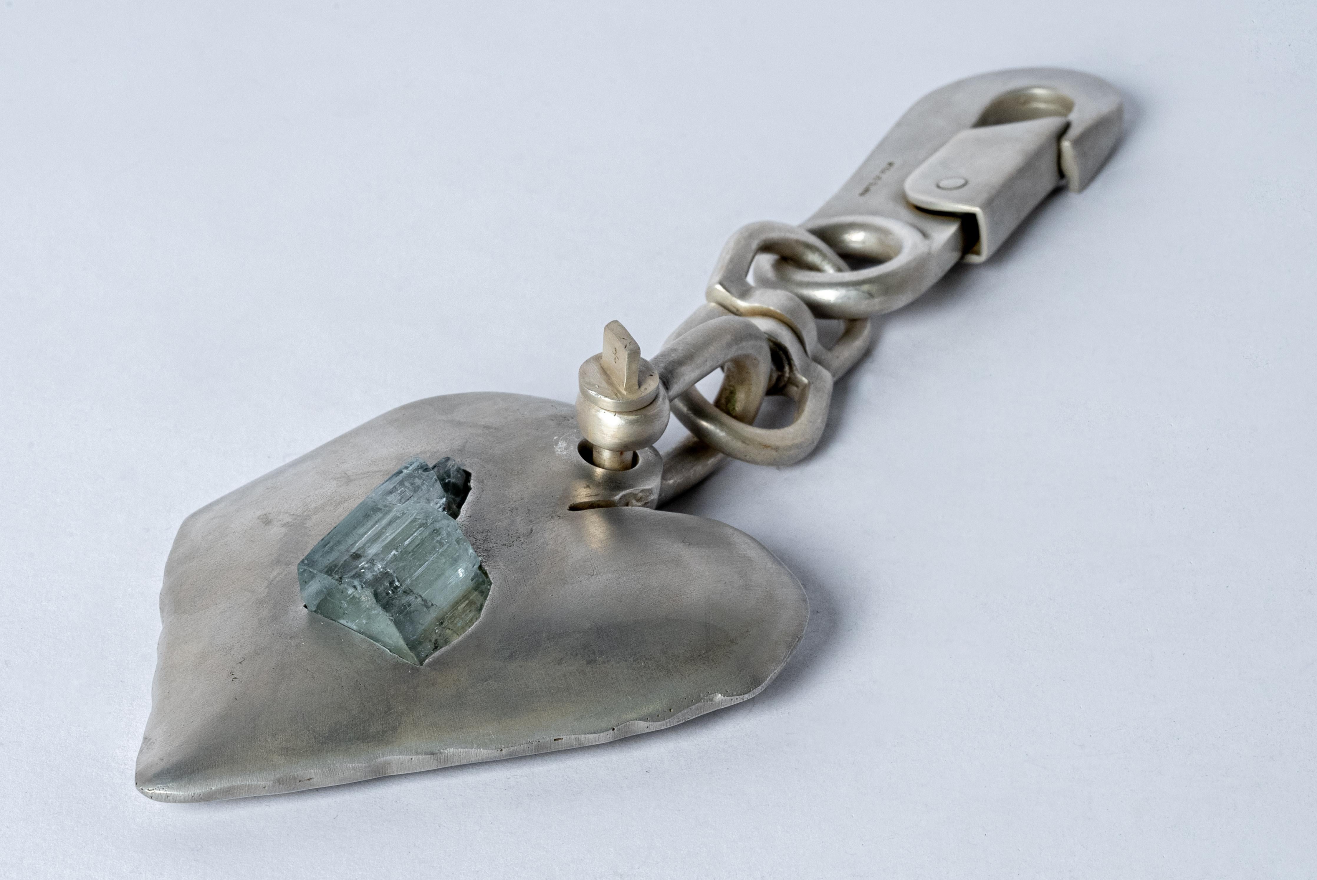 Charm in brass and a slab of rough aquamarine. Brass substrate is electroplated with silver and then dipped into acid to create the subtly destroyed surface. No two items are the same and these nuances / variations should be seen as a characteristic