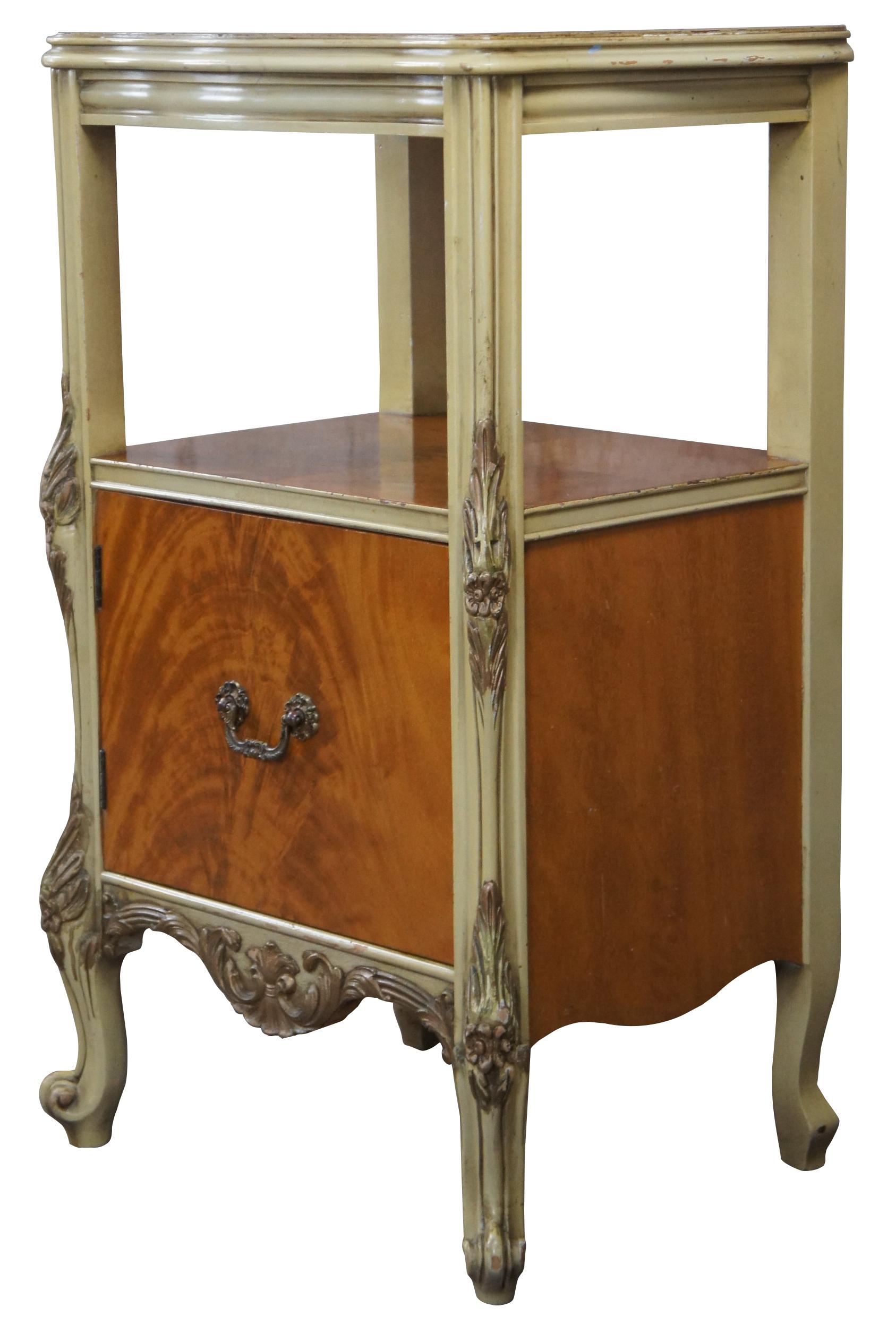 Elegant satinwood nightstand with ornate hand painted gold trim by J.B. Van Sciver Co. A Serpentine form with tiered design allowing for two surfaces for display. Lower Door opens with a cast bronze pull for storage. Made by the J. B. Van Sciver Co.
