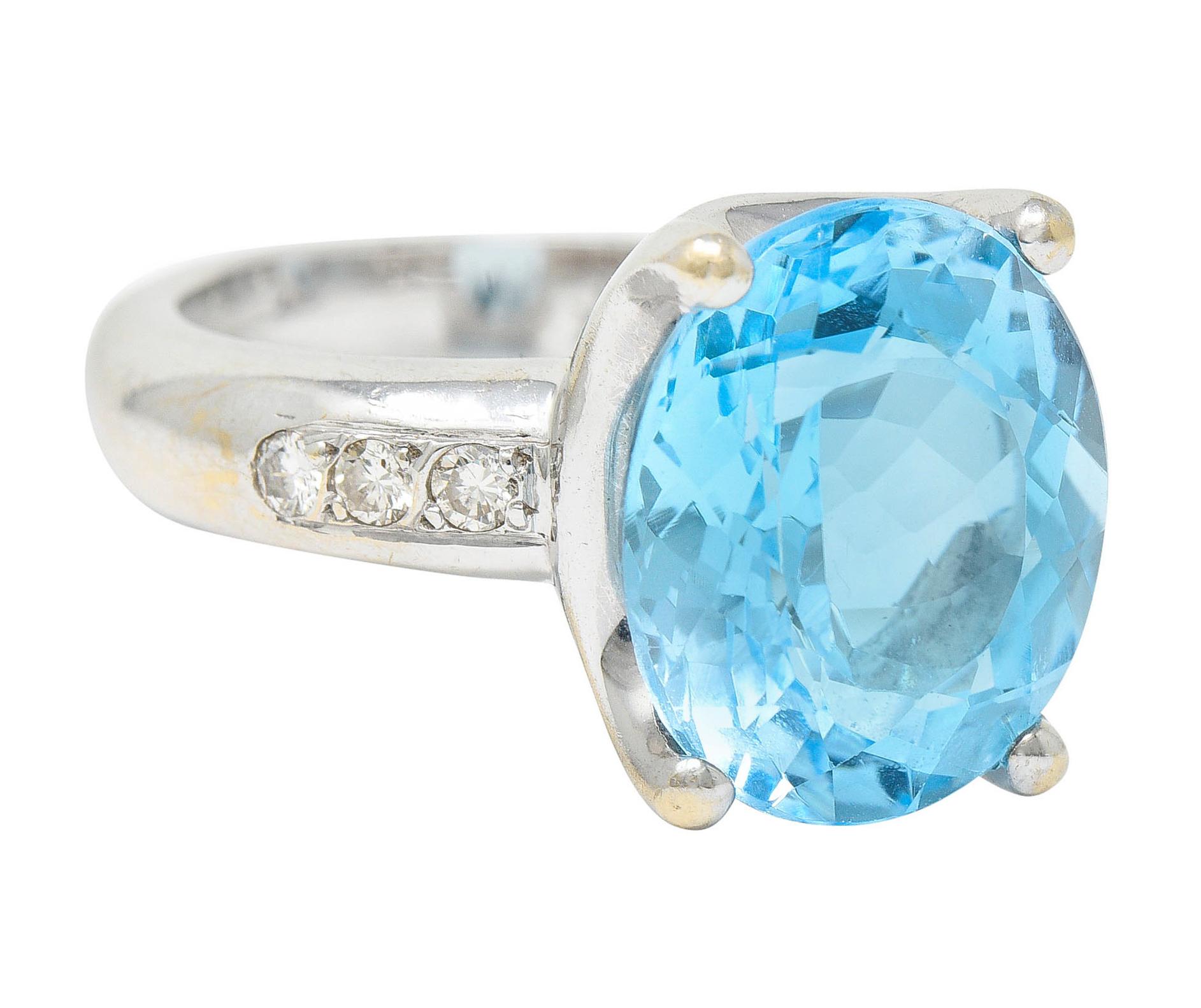 Centering an oval mixed cut blue topaz measuring approximately 14.0 x 12.0 mm

Transparent with uniform medium light sky blue color

Set in a stylized basket and with a puffed band shank

Accented by round brilliant cut diamonds weighing in total