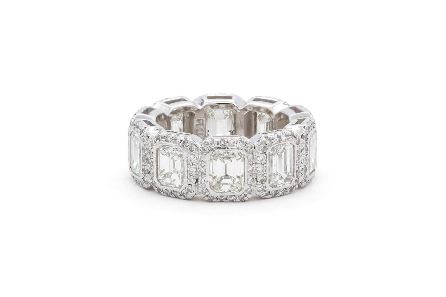 We are pleased to offer this JB Star Platinum & Emerald Cut Diamond Halo Eternity Band. This stunningly beautiful eternity band features 10 emerald cut diamonds, each accented by a halo of round brilliant diamonds. The total carat weight is