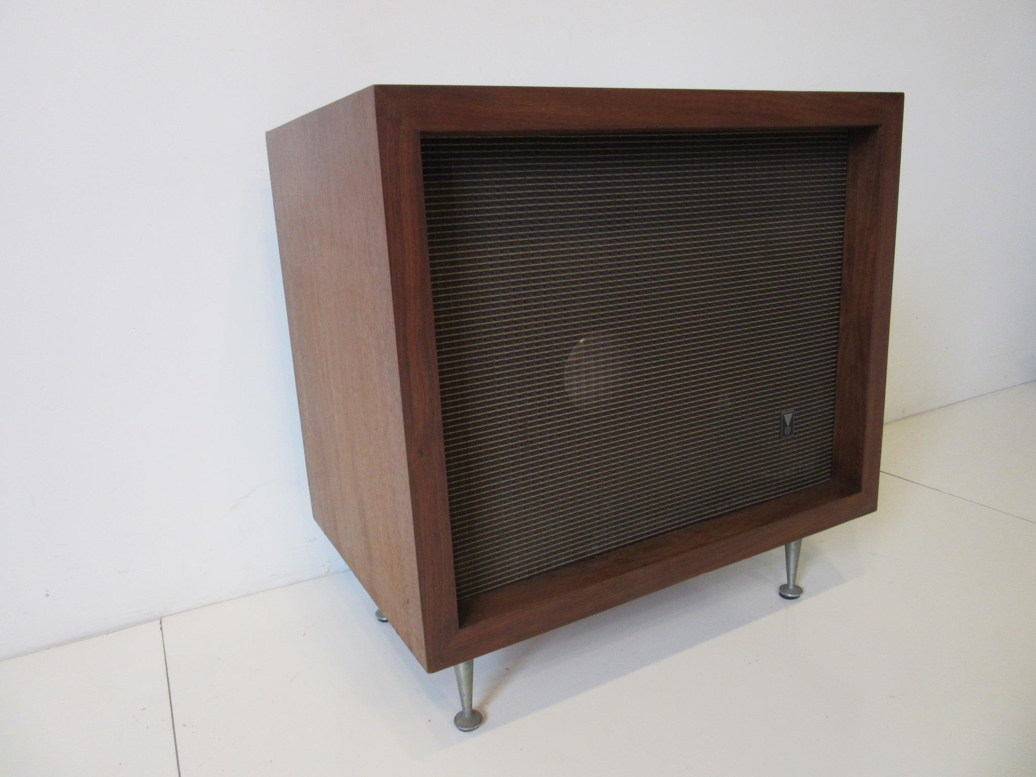 A JBL speaker with a medium toned walnut cabinet model # C-38 with cast aluminum legs in the style of George Nelson. Inside the enclosure contains one single model # D-130 loudspeaker which retains the original tag to the backside of the speaker and