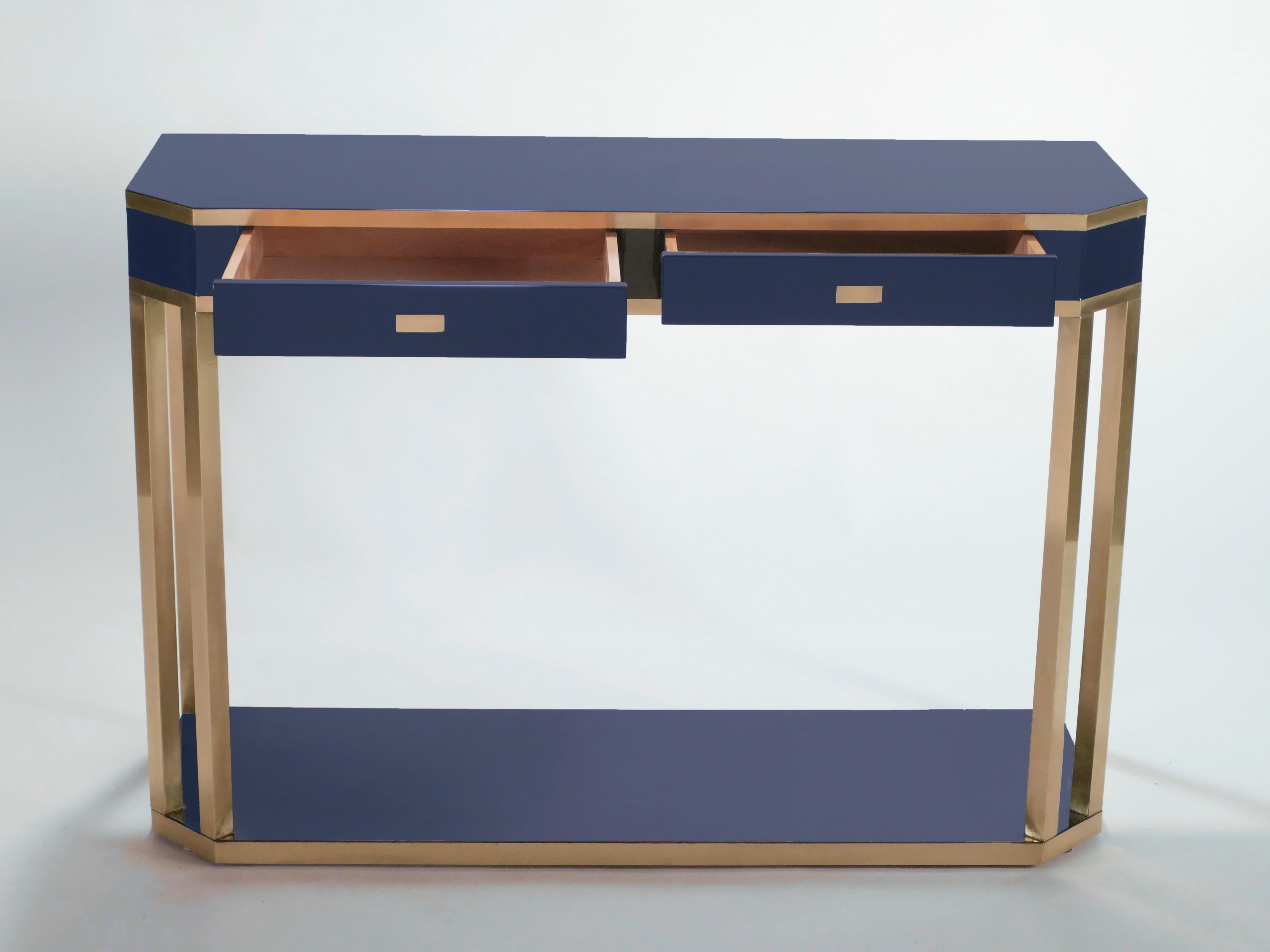 With a shining blue lacquered top, and sharply geometric brass legs and details, this console table carries a stellar futuristic midcentury aesthetic into the contemporary home. Its boxy yet sophisticated style is typical of both the 1970s and