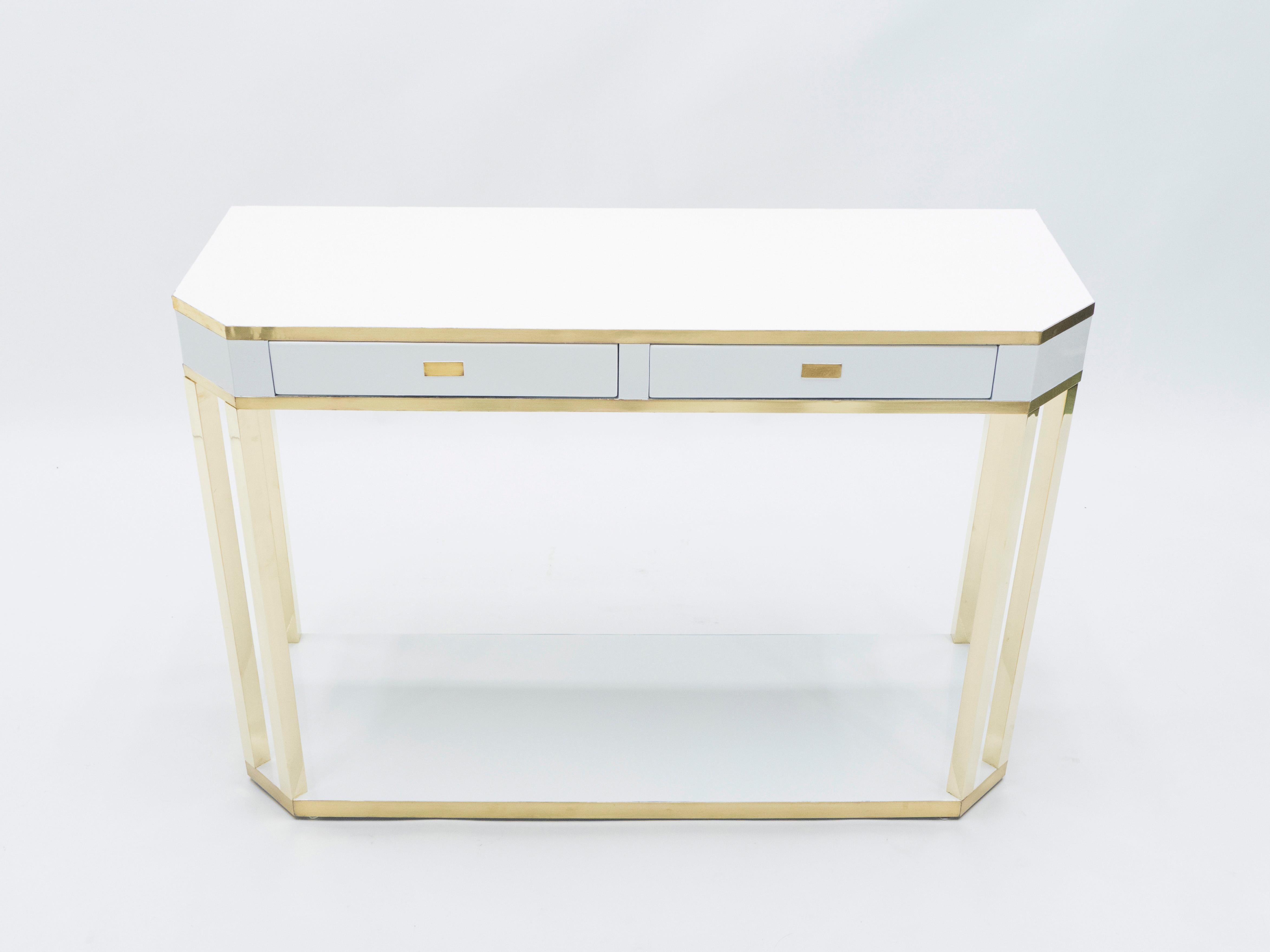 With a shining white lacquered top, and sharply geometric brass legs and details, this console table carries a stellar futuristic midcentury aesthetic into the contemporary home. Its boxy yet sophisticated style is typical of both the 1970s and