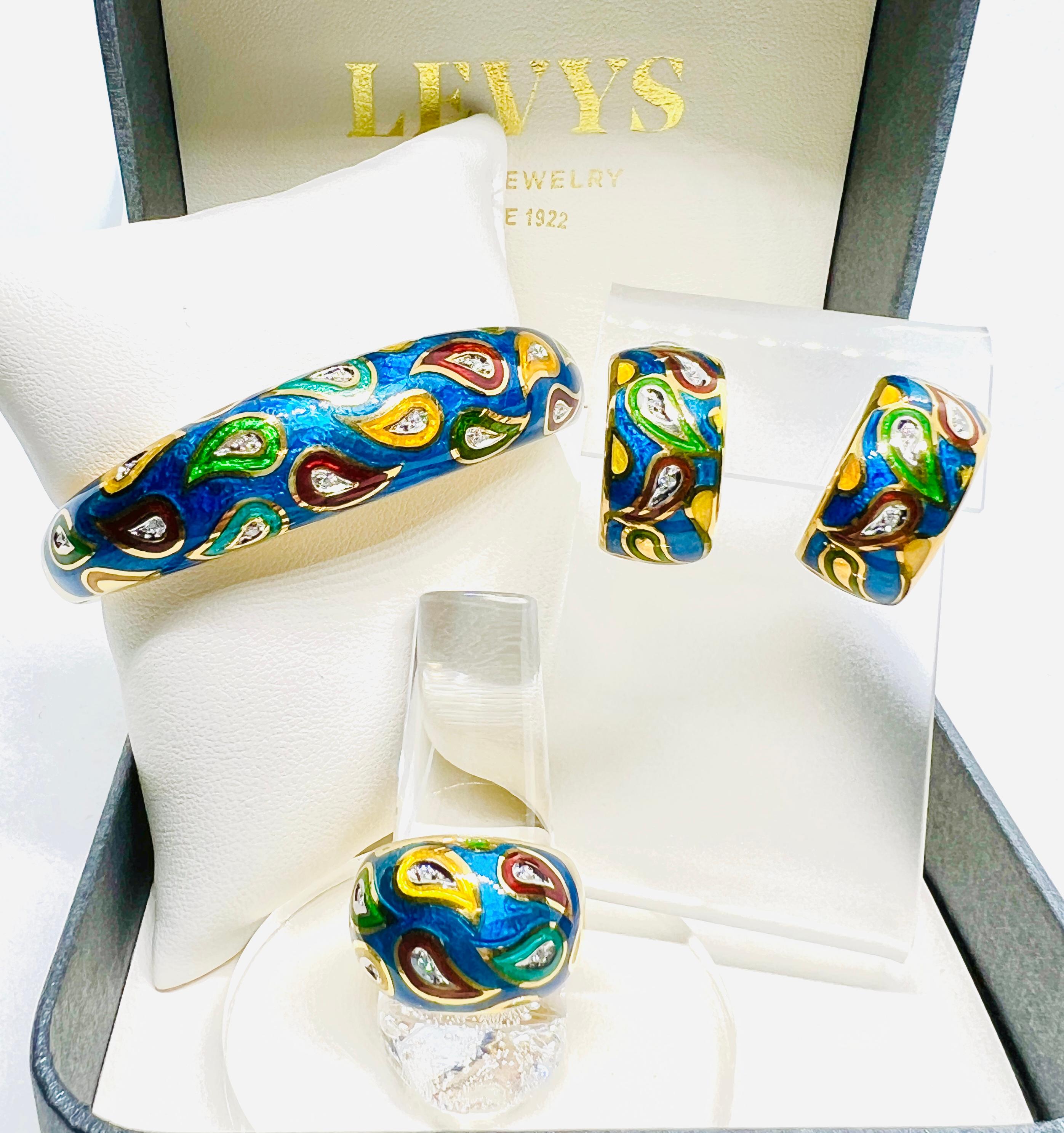 This is a gorgeous suite! Made in 18k yellow gold and features multi colored enamel (blue, green, yellow and red) in a paisley pattern. The ring is a size 7.5, features 6 diamonds and weighs 13.6 grams. The earrings measure 1 inch by 1/2 inch, have