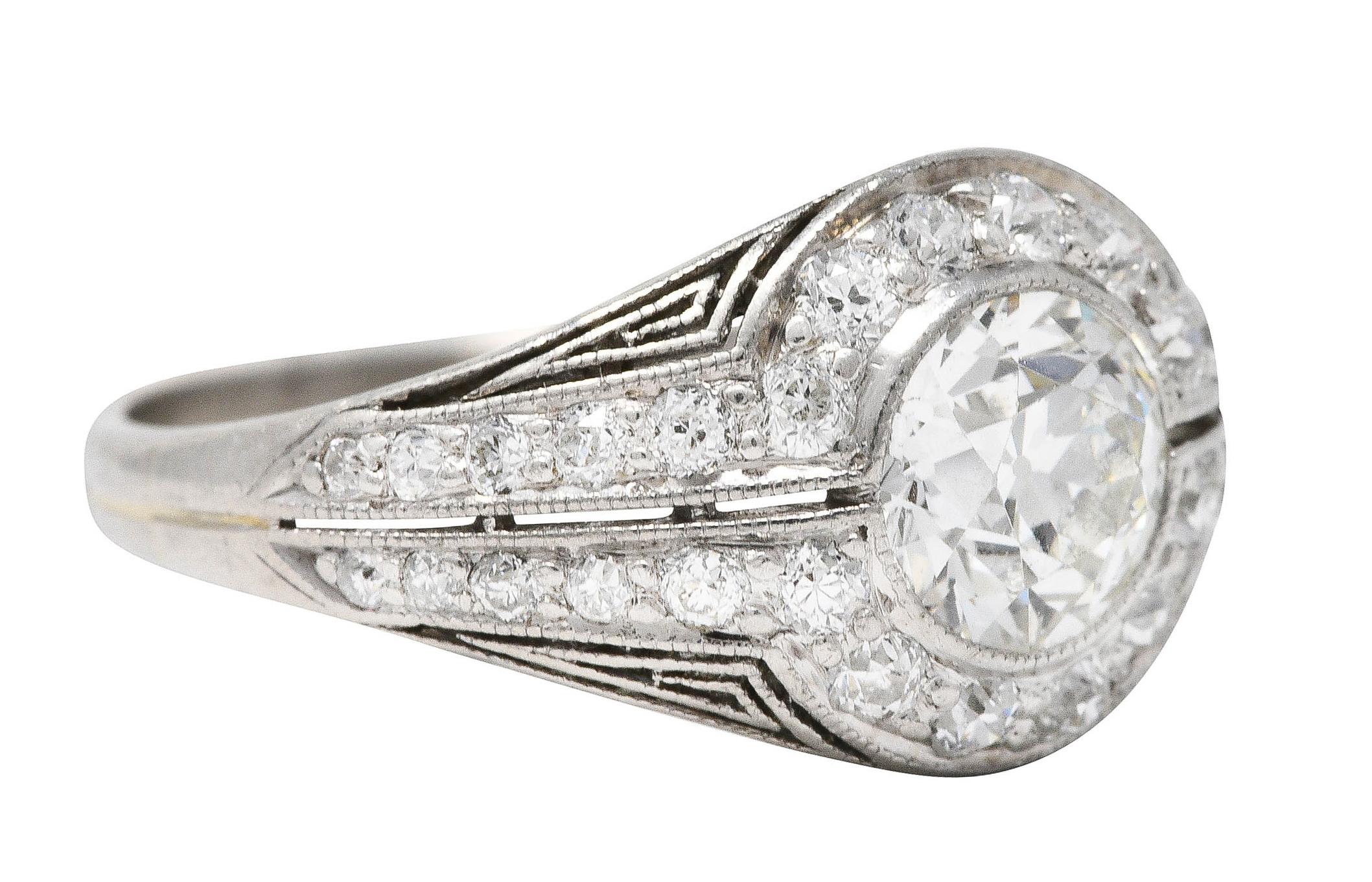 Bombè-Ring mit einem Diamanten im alten europäischen Schliff mit einem Gewicht von ca. 0,70 Karat - Farbe J und Reinheit VS

Lünette gefasst und umgeben von einem runden Halo aus Diamanten im alten europäischen Schliff

Dann flankiert von weiteren