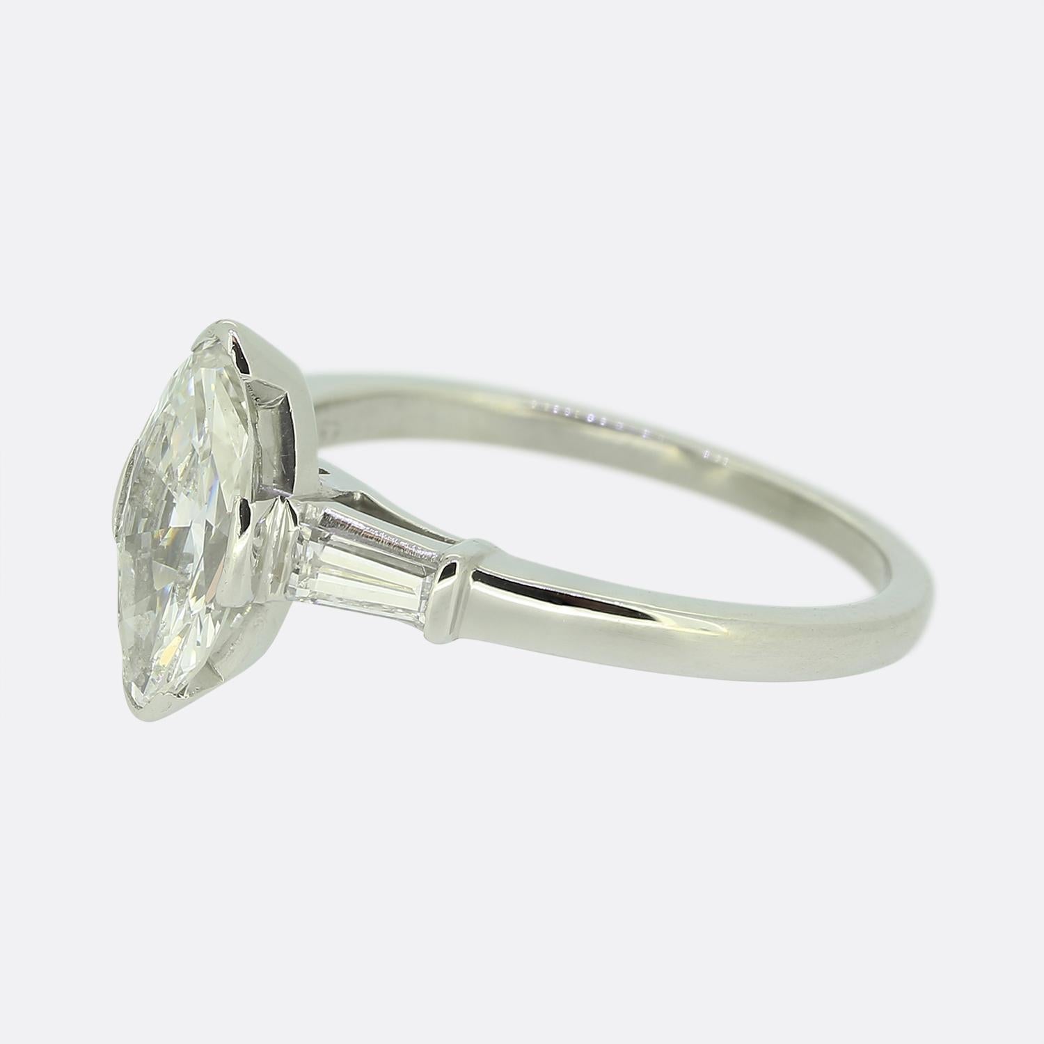 Here we have an exquisite engagement ring crafted by J.E. Caldwell & Co. in during the mid century period. The platinum piece features a striking marquise-cut diamond at the centre exuding elegance and brilliance. Flanking this principal stone is a