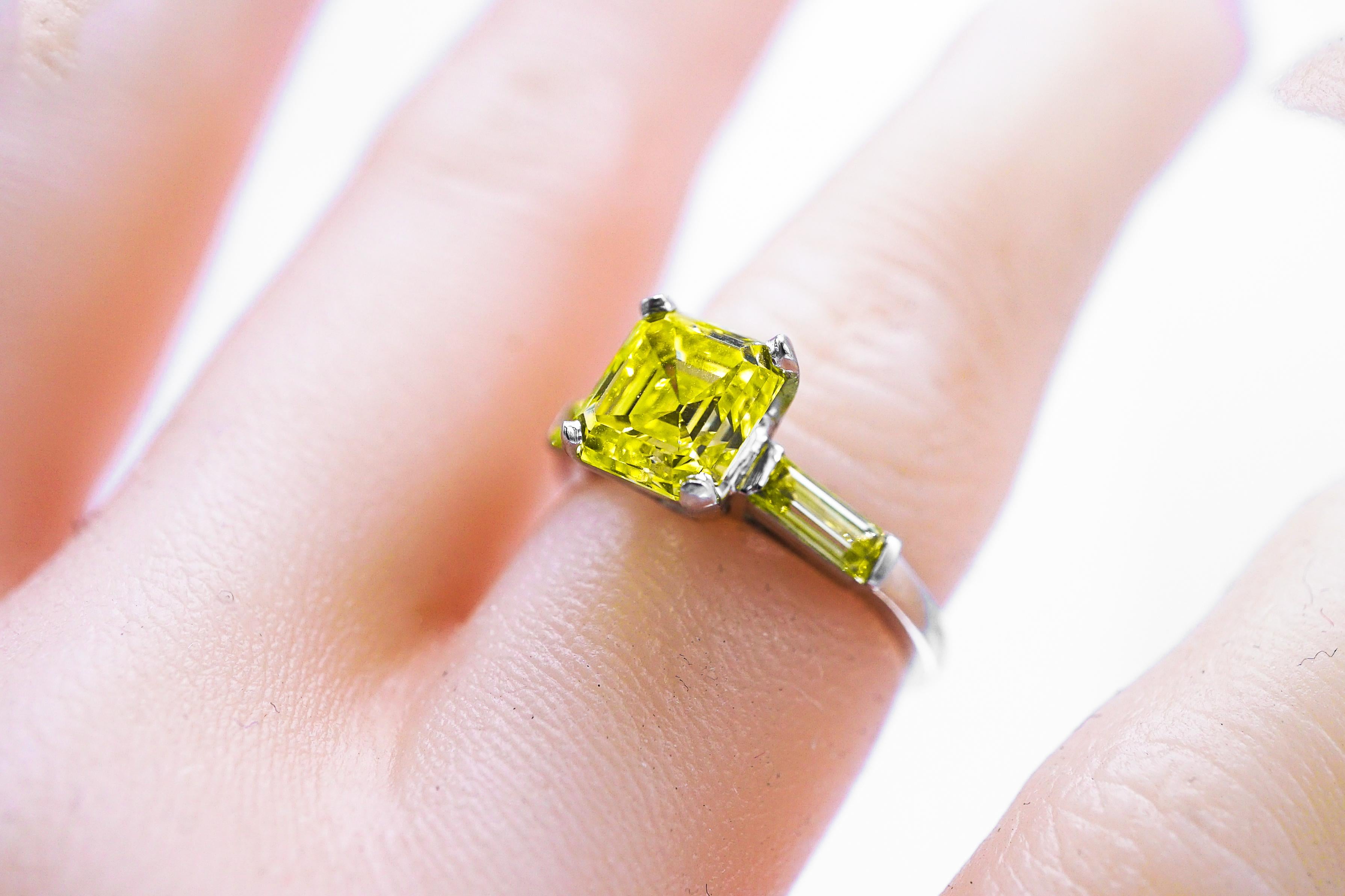 This J.E. Caldwell & Co Platinum Yellow Diamond and Diamond Ring centers one cut-cornered step-cut emerald-cut Fancy Vivid Yellow diamond and approximately 2.26 cts., and is flanked by 2 light yellow baguette diamonds, signed J.E.C. & Co., no.