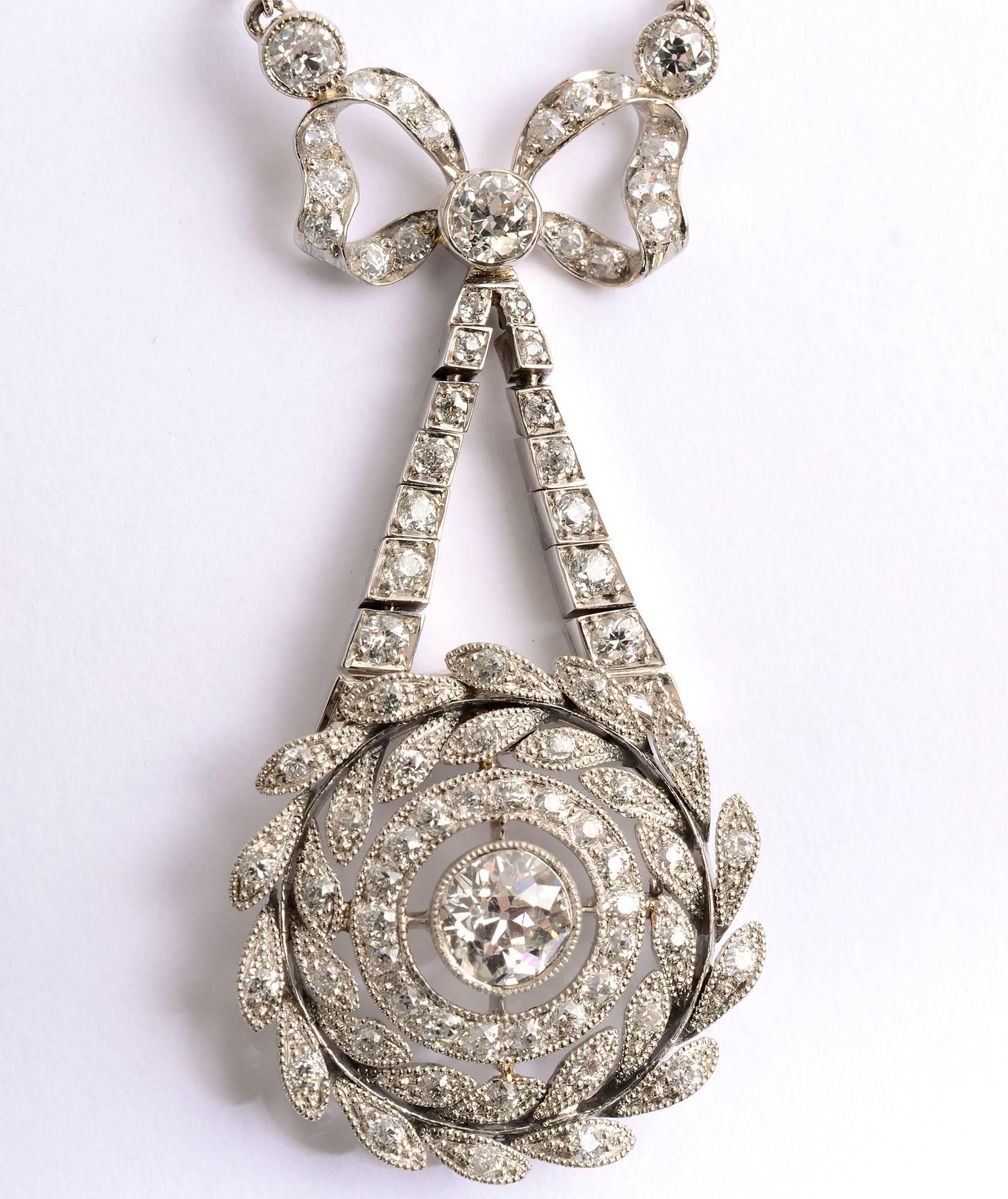 Elegant Edwardian diamond pendant necklace by J.E. Caldwell, one of America's earliest jewelers. The firm was established in 1839 and flourished with their Edwardian and Art Deco jewelry. 
This elegant bow pendant terminating in wreaths of diamond