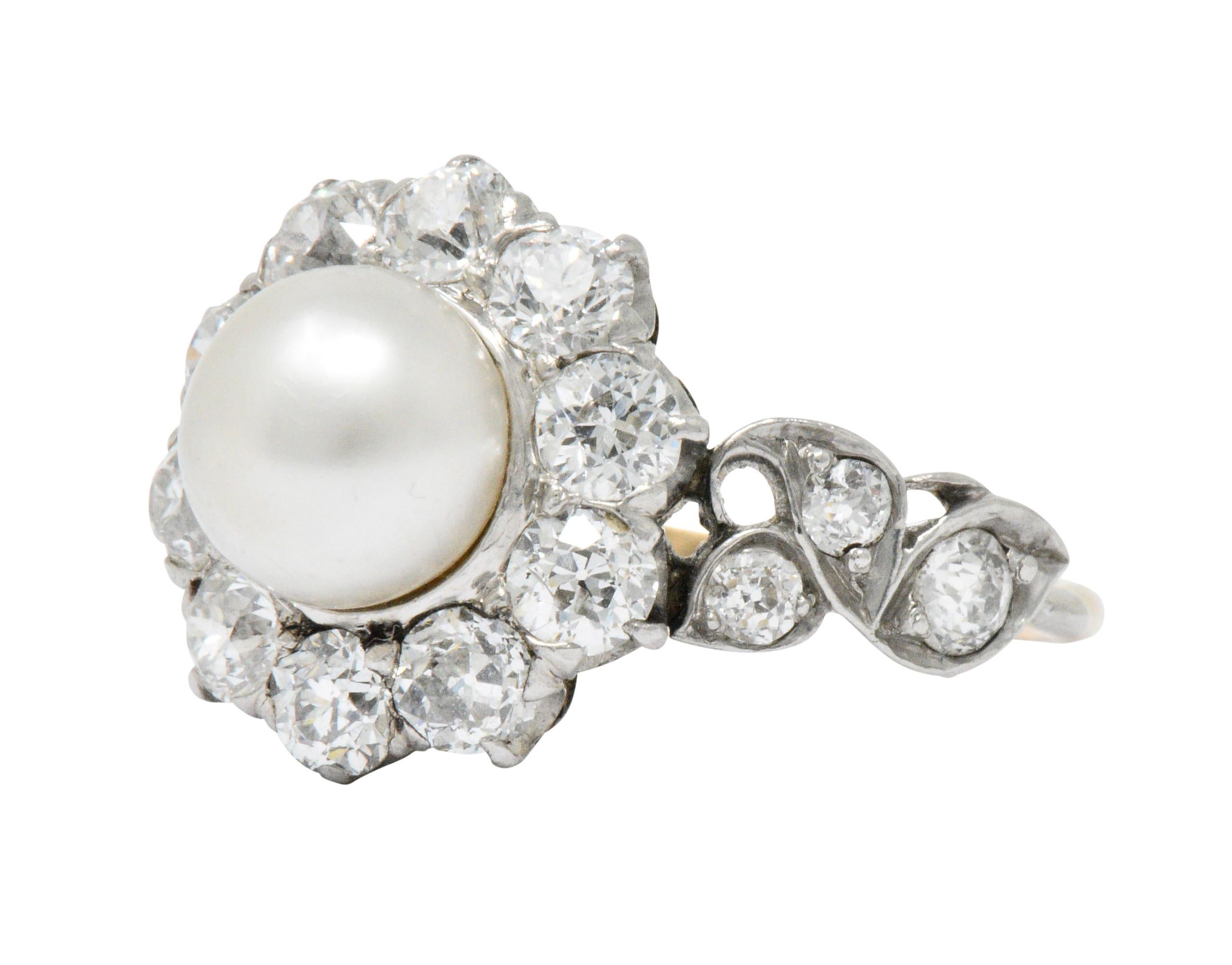 Centering a button shaped natural pearl, measuring approximately 7.0 mm, white body color with very good luster and surface quality

Old mine cut diamond surround and side accents, weighing approximately 1.50 carats total, G/H color and VS to SI
