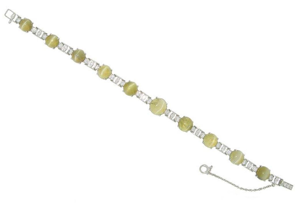 J. E. Caldwell chrysoberyl cat's eye and diamond bracelet. Set with a ten graduated round cabochon natural unenhanced cat's eye chrysoberyl in open back claw settings with an approximate combined weight of 28.00 carats, each flanked by two round old