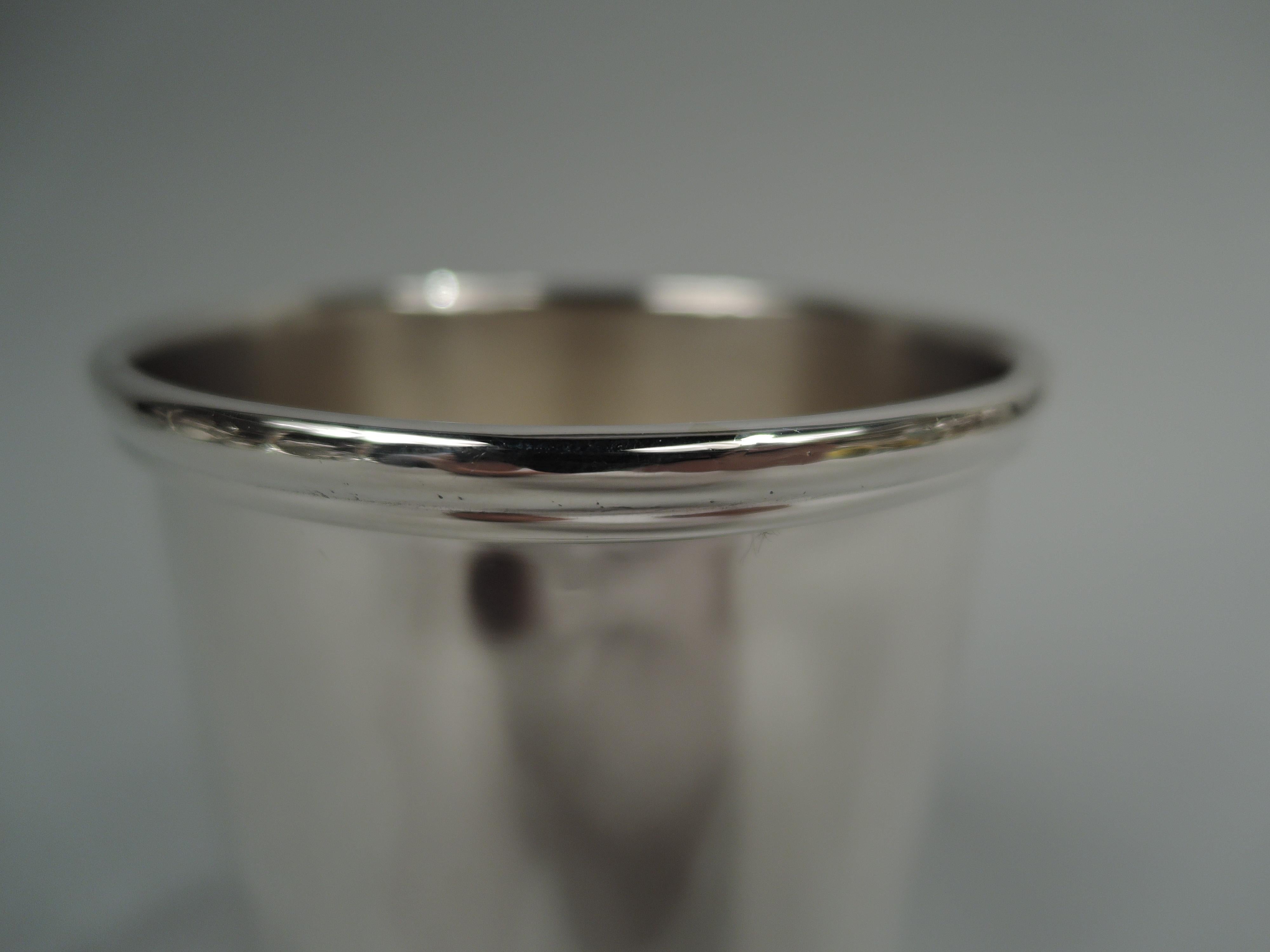 Small American sterling silver mint julep cup, ca 1930. Retailed by JE Caldwell in Philadelphia. Straight sides with molded rim and stepped foot. Fully marked including retailer’s stamp, no. 587, and phrase “Washington / Reproduction”. Weight: 3.3