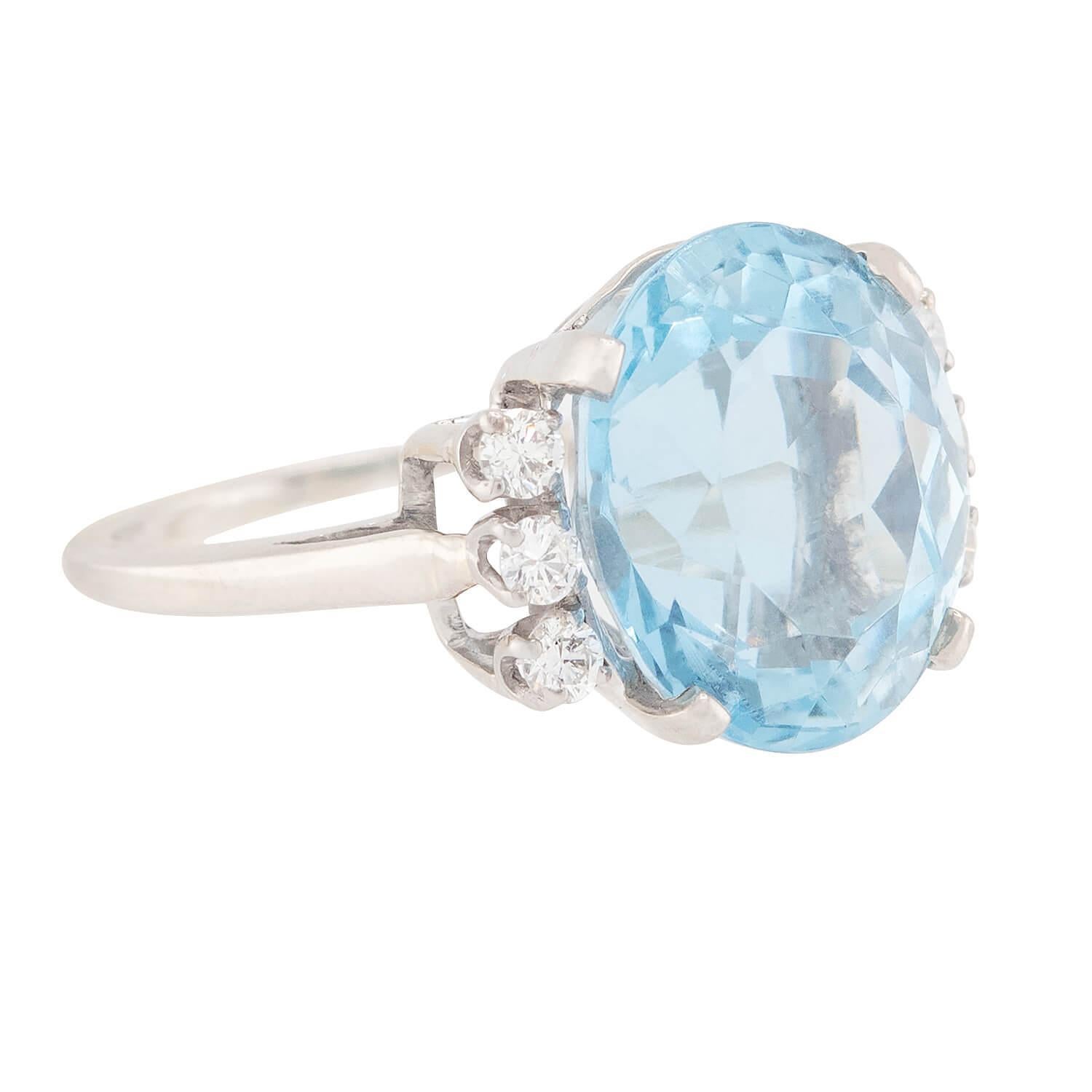 Un asombroso J.E. ¡Anillo Caldwell de aguamarina y diamantes de la época Vintage (ca1960s)! Esta hermosa pieza está elaborada en oro blanco de 14 quilates y tiene una piedra central de color aguamarina de 10 quilates en un engaste de cuatro puntas.