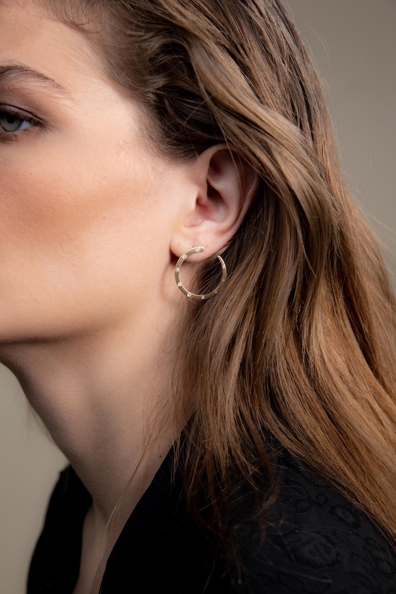 Quadrant earring from the METRO collection. 

14K gold and diamond crescent shaped post earrings gently scoop below your lobe giving an attractive take on a post earring. Diamonds are subtly graduated.  The texture is a brushed finish with a 1 inch