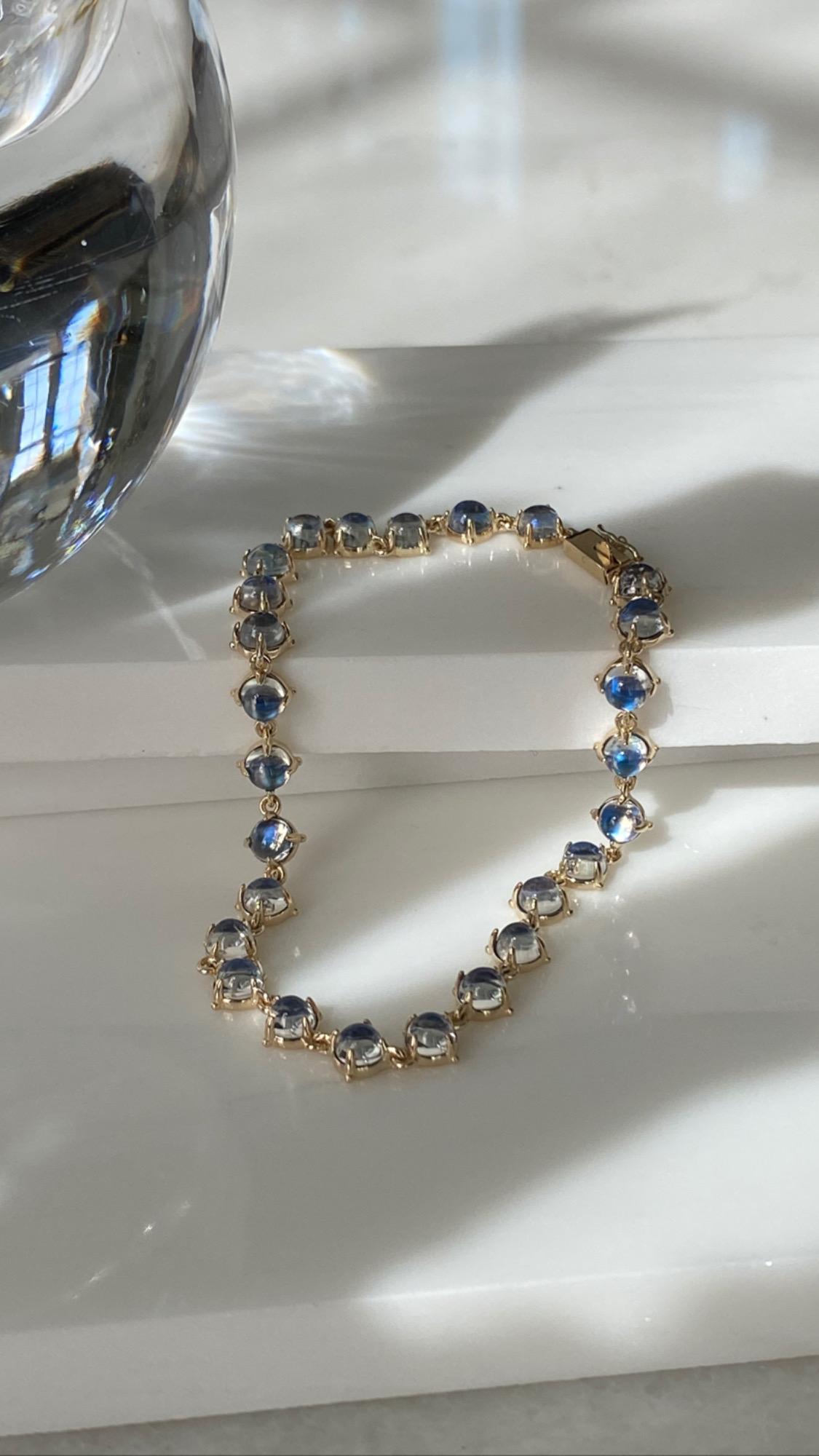Jean Basse Royal Blue Cabochon Moonstone Tennis Bracelet. The bracelet houses 26 4mm moonstones nestled in a 14K polish gold setting and push clasp with a safety closure. The length is 6.75 inches. The stones were hand picked for their quality. 


