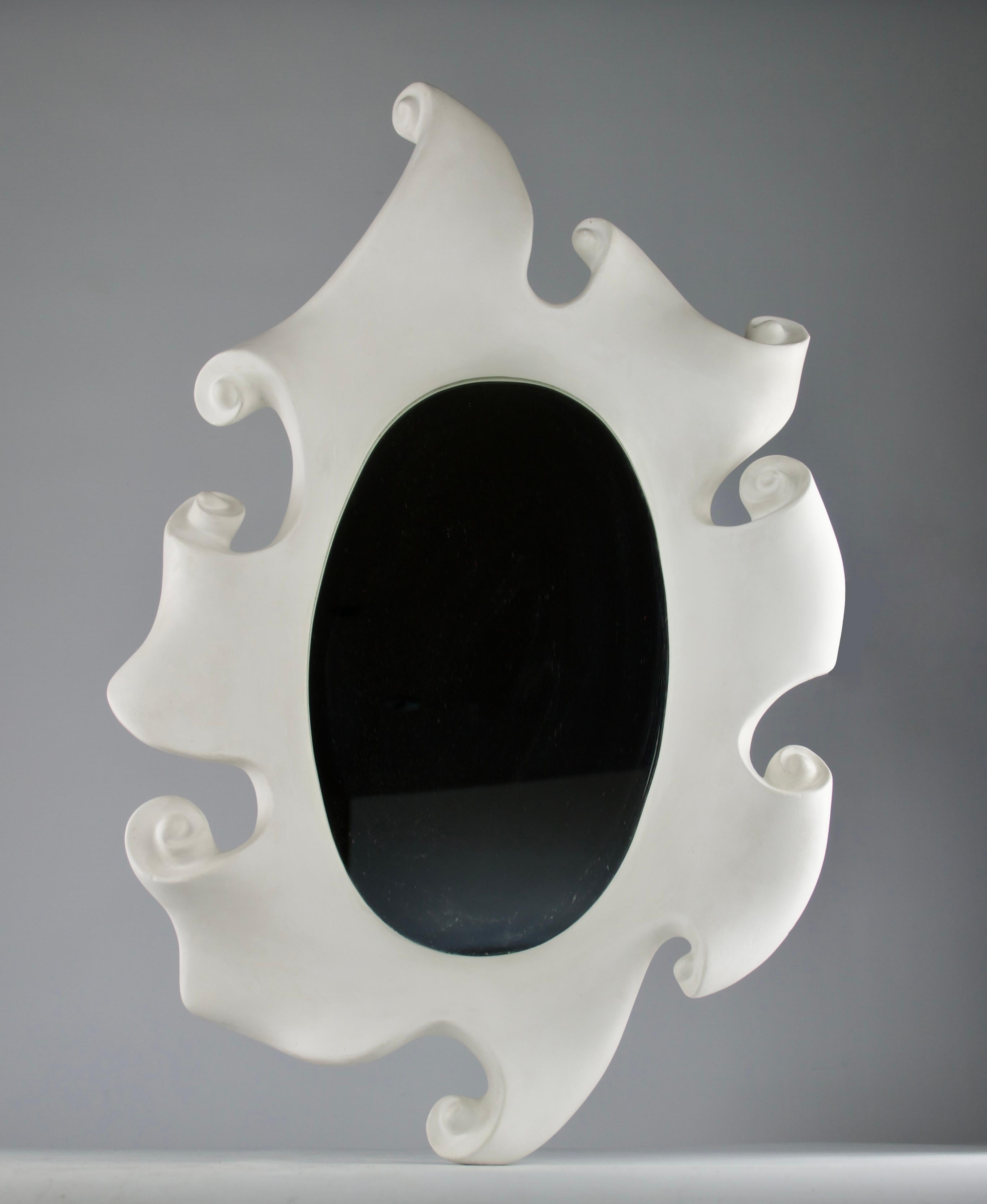 Hervorragender und seltener Spiegel von Jean Boggio für Les Héritiers. Dieser außergewöhnliche Spiegel ist ein eindrucksvolles Beispiel für die skurrile und zugleich anspruchsvolle Ästhetik des Designers. Der organisch geformte Gipsrahmen windet