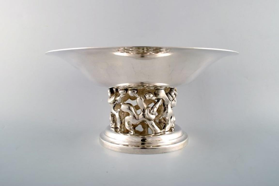 Jean Boggio for Roux-Marquiand, France.
Large modernist compote in plated silver. 
A base with a motive of dancing circus artists.
In very good condition.
Stamped.
Measures: 30.5 cm x 14.5 cm.
