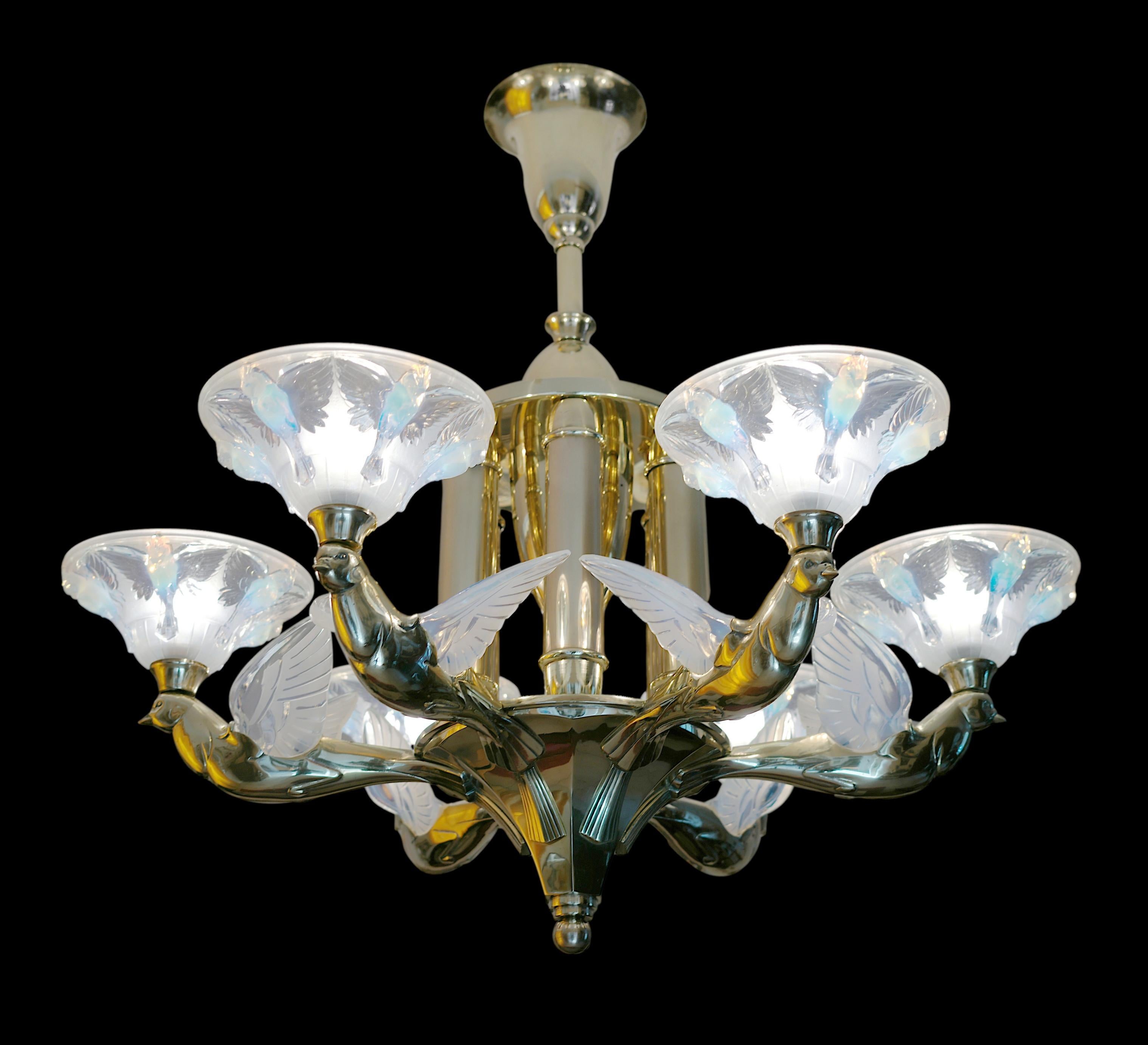 Questo eccezionale e raro lampadario francese Art Déco, creato dal famoso designer Jean Boris Lacroix negli anni '1920, presenta sei spessi paralumi in vetro stampato opalescente ornati da delicati motivi di uccelli. Ogni paralume è sostenuto da una