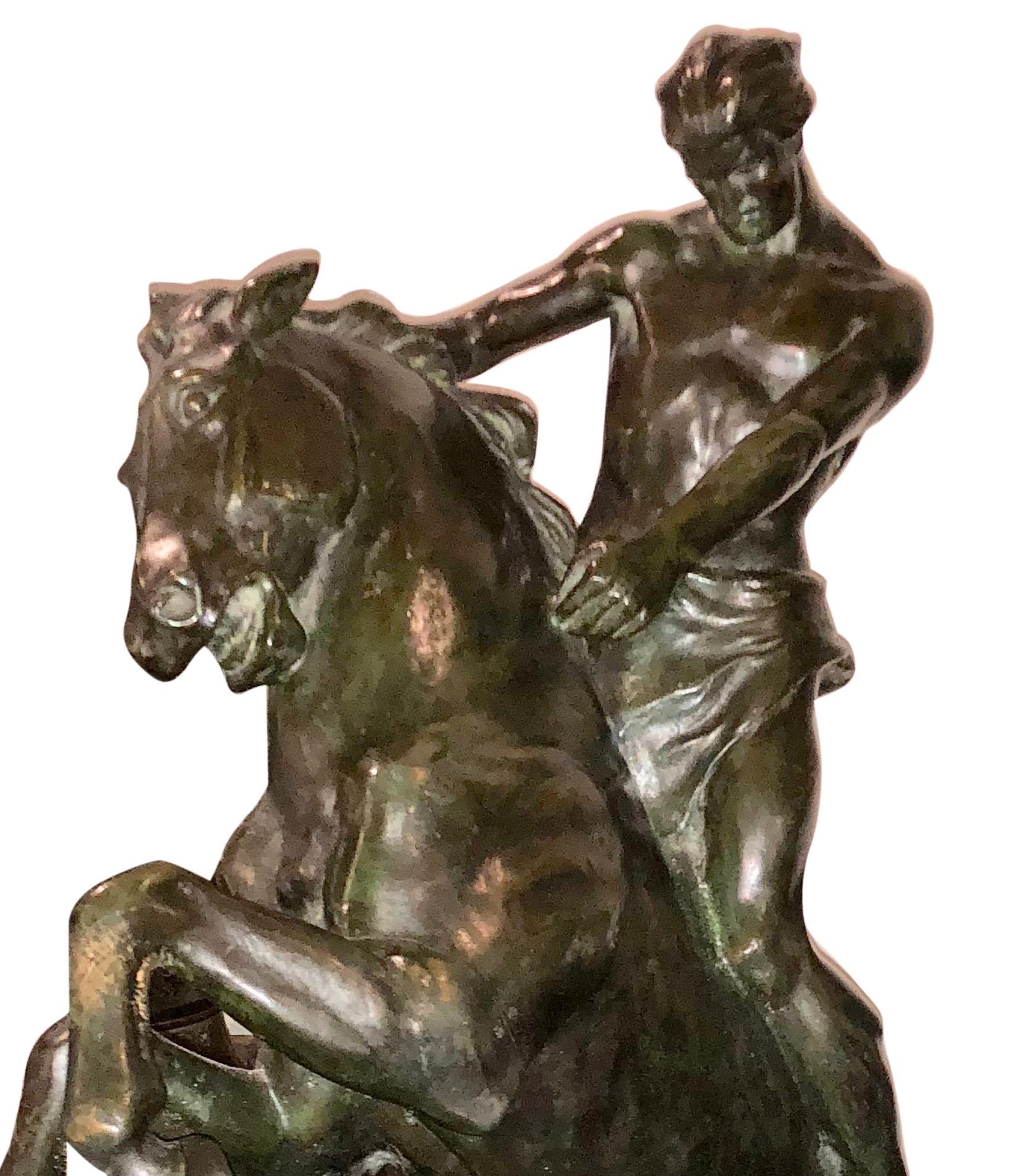 Impressive bronze sculpture by International artist Jean Canneel. A serious statue depicting a man on horse. The figures of both the man and horse are rendered Art Nouveau to Art Deco realistic style, the figure is mounted on red marble. Artist