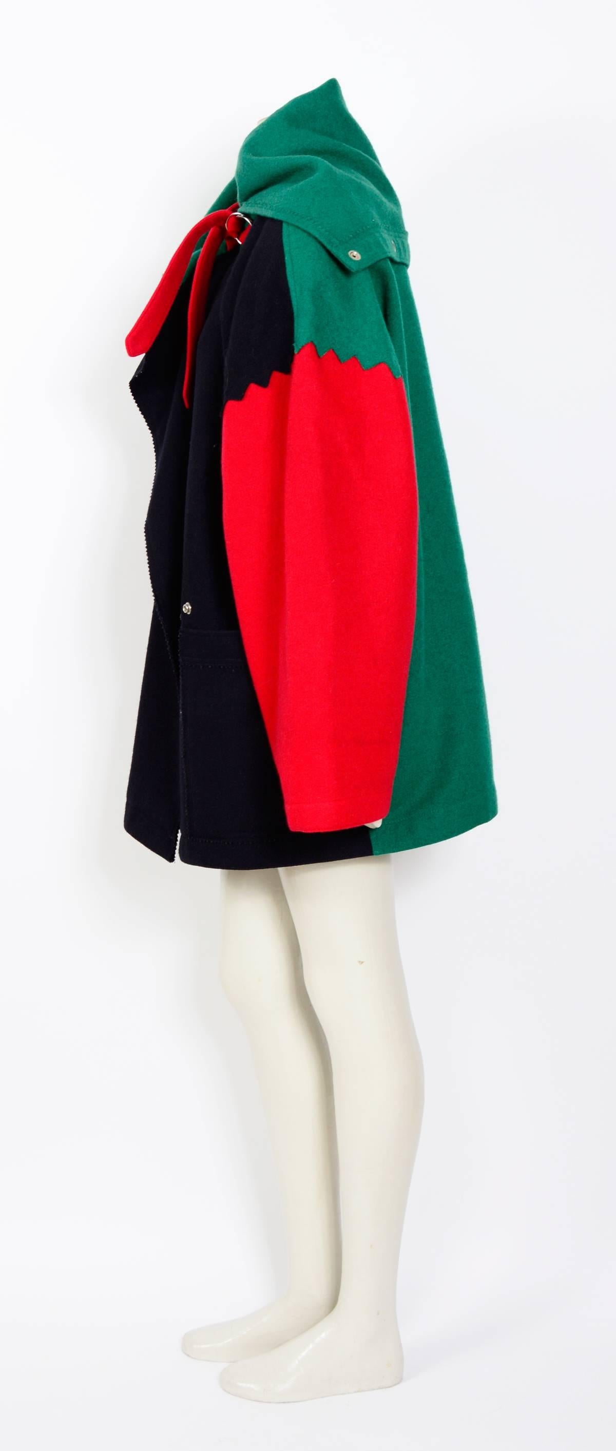 Manteau gigantesque en laine colorée des années 1980 de Jean Charles de Castelbajac. Les épaulettes d'origine datant des années 80 sont toujours dans le manteau, il est fort probable que cette pièce n'ait pas vu la lumière du jour depuis. L'heure du