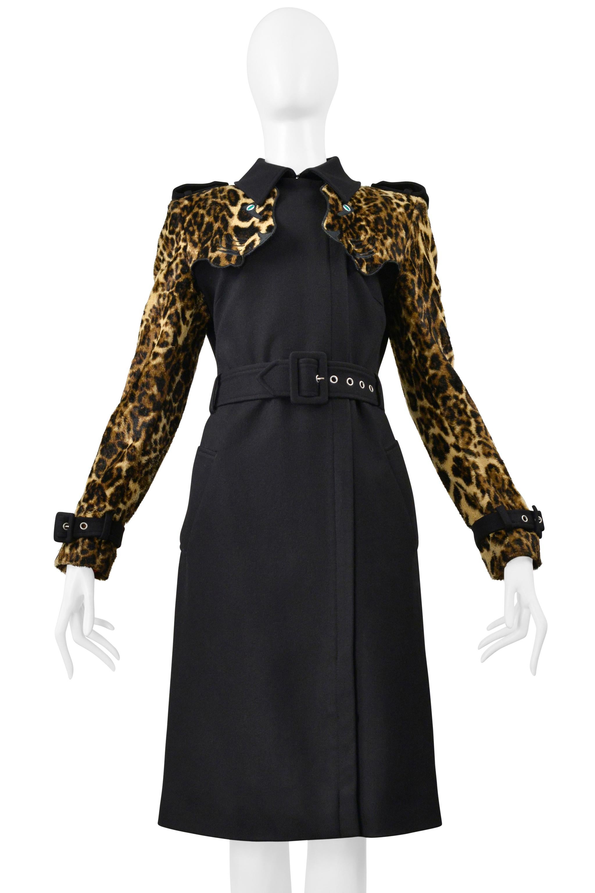 Resurrection è lieta di offrire un trench nero Jean-Charles de Castelbajac con maniche leopardate, teste di leopardo con occhi verdi sulle spalle, cinture con fibbie sui polsini, cintura in vita con fibbia nera e gommini argentati, colletto