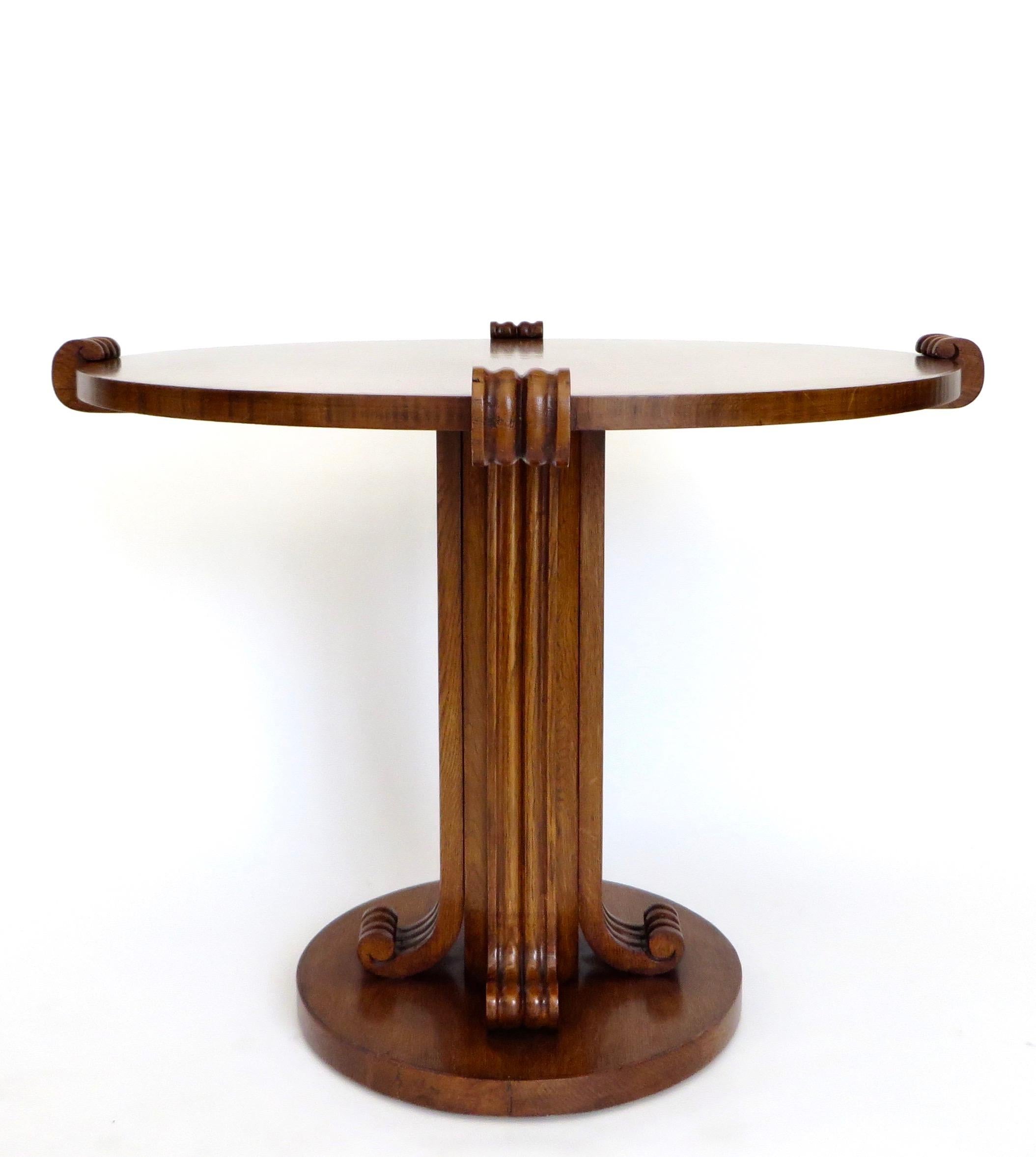An icon of French 1940s design, this rare round small dining, side or centre table by Jean-Charles Moreux (1889-1956), has a round top and sculptural base having four heavily scrolled supporting arms. This is a rare iteration in handsome figurative