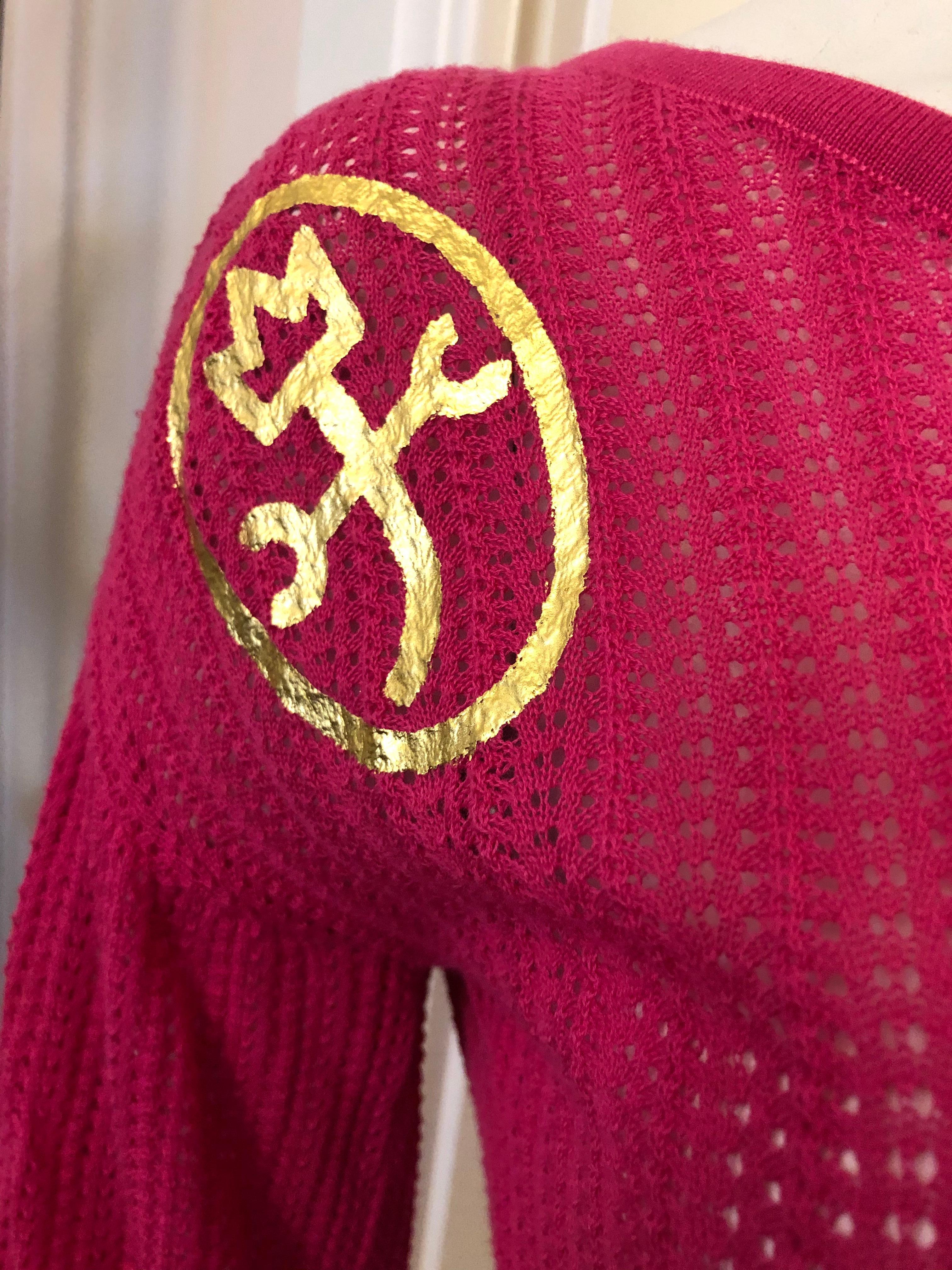 Ribbed Fuschia cotton top with elbow length sleeves and JC Castelbajac logo in gold. There are also nine gold tone signed button.
