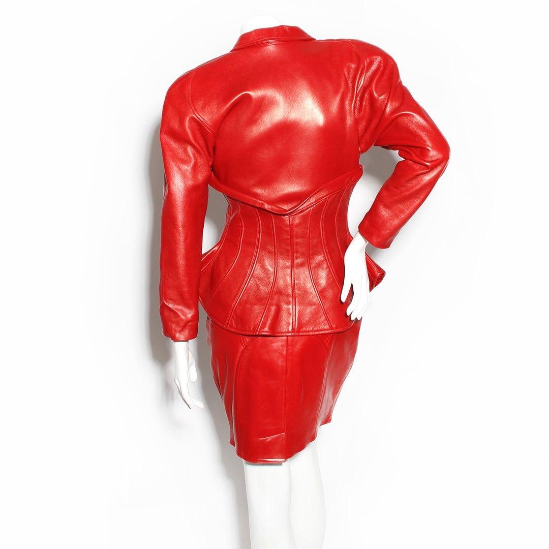 Corset suit by Jean Claude Jitrois 
Circa 1987
Red leather suit 
Long sleeve 
Corset front closure 
Two side pockets 
Slight shoulder pad 
Decorative seams 
Boning in jacket to create shape 
Winged waistband
Red leather skirt 
High waist skirt 
Zip