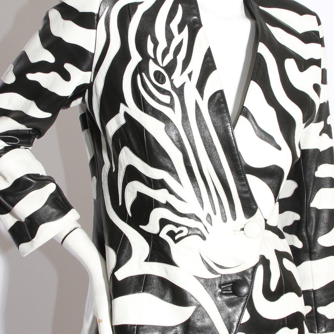 Zebra jacket by Jean Claude Jitrois
Circa 1980s 
Leather jacket 
Black and white zebra print with face detail 
Graphic design
Button-front closure
Faux button cuff
Strong silhouette
Shoulder pads
V-neck 
Asymmetrical hem
Fully lined interior
Made in