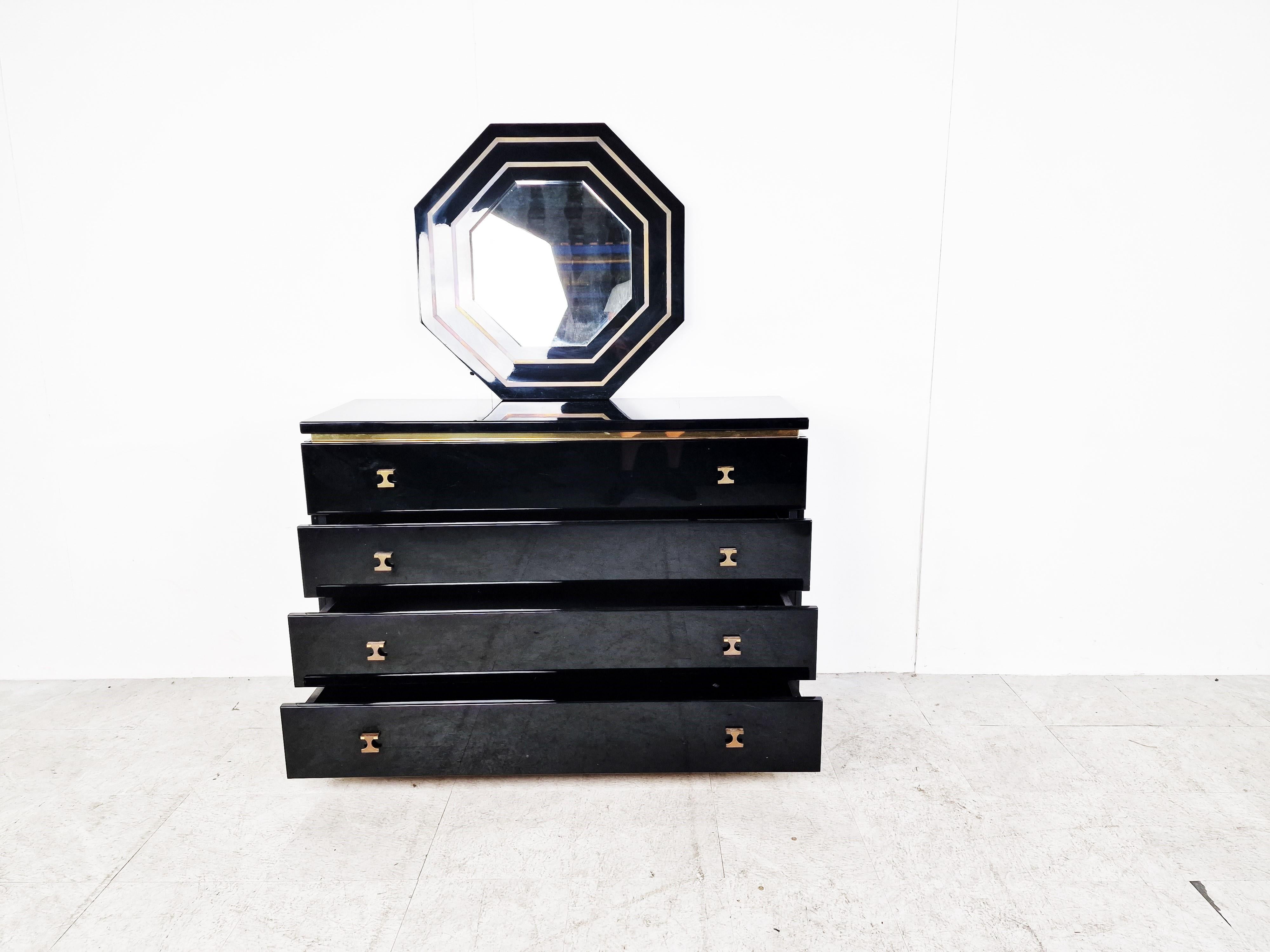 Beautiful black lacquer and brass chest of drawers by Jean Claude Mahey with matching octogonal mirror.

The chest of drawers is made of high quality materials and has a great 1970s - 1980s glamourous look.

It has 4 drawers.

Good