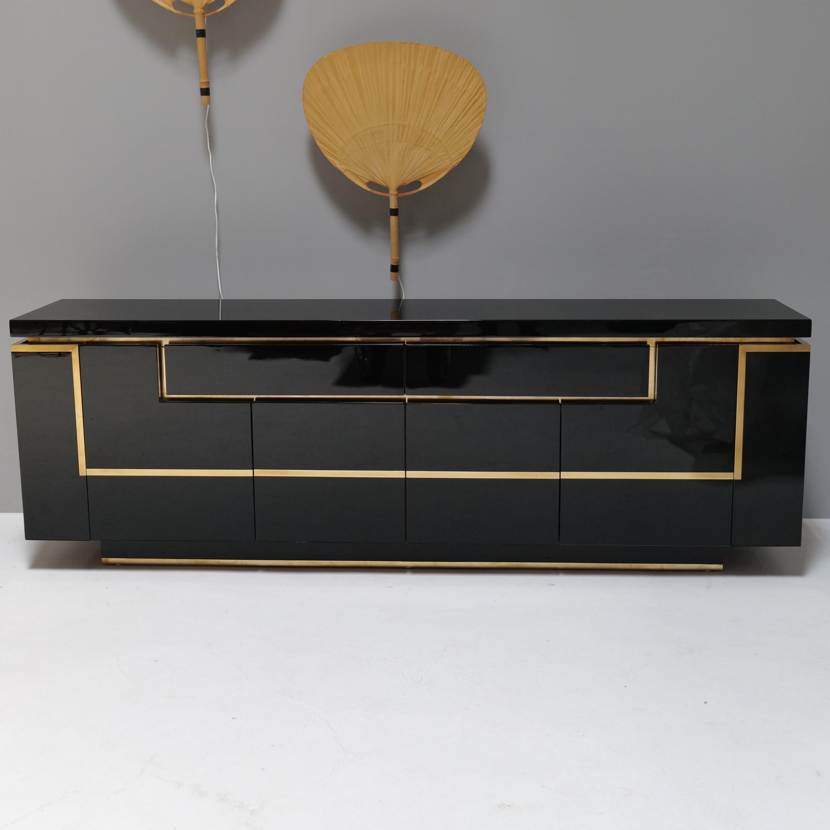 Large sideboard made of brass and black high-gloss piano lacquer.
Behind the two outer hinged doors is the elegantly integrated bar.
The beautifully crafted interior compartments perfectly complement the brass elements and also provide plenty of