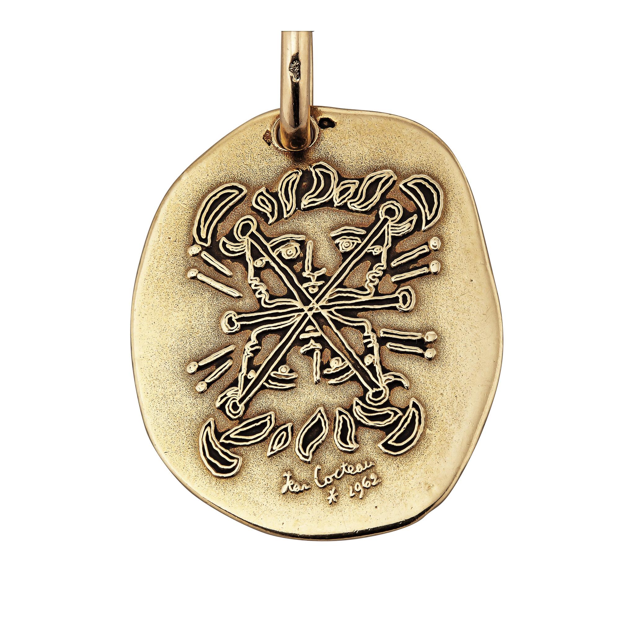 Designed by Jean Cocteau and Fred Paris, this whimsical mid-century gold disc pendant necklace features six hidden faces within its mesmerizing frontal sketch.  Jean Cocteau, known as a brilliant French playwright, poet, film maker, designer, and