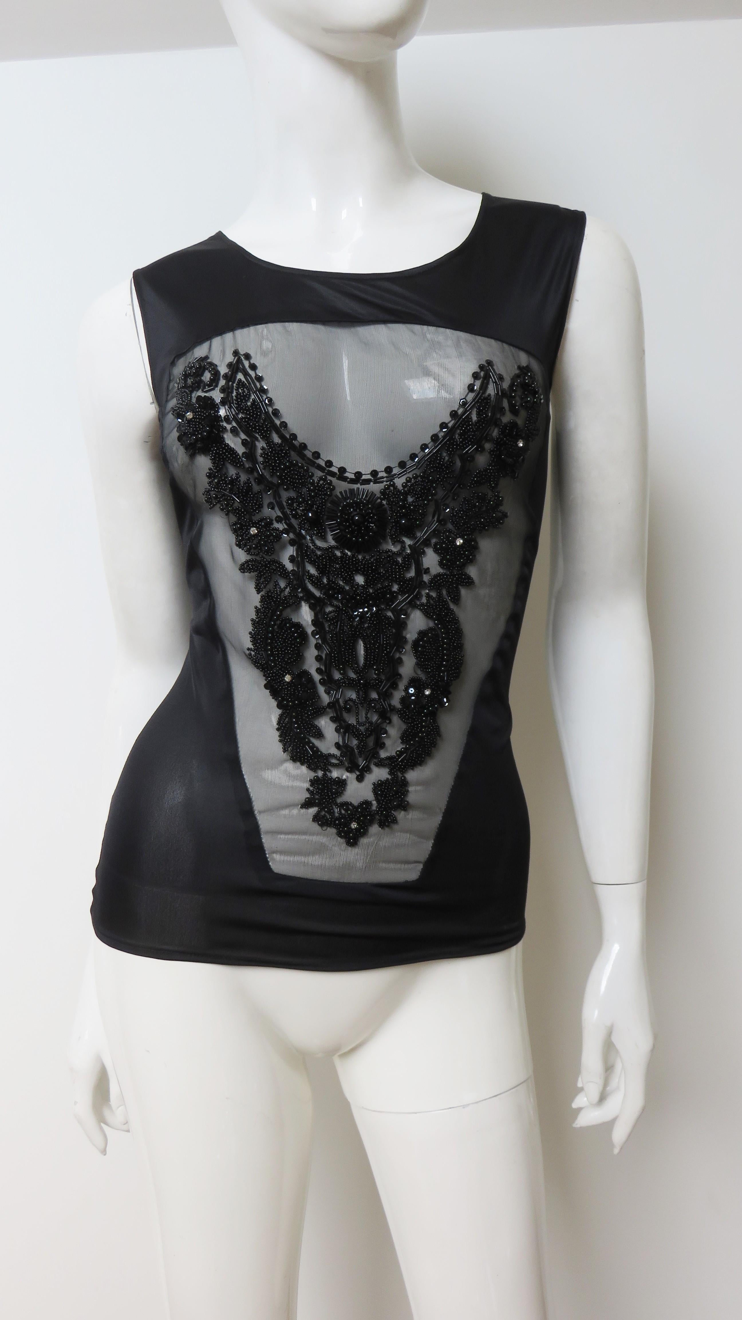A fabulous black beaded top from Jean Colonna.  It is sleeveless with a crew neckline and a front sheer panel adorned with an elaborate pattern of  black glass tubular, seed and round beads. Gorgeous. The back is solid opaque black.
Fits sizes Extra