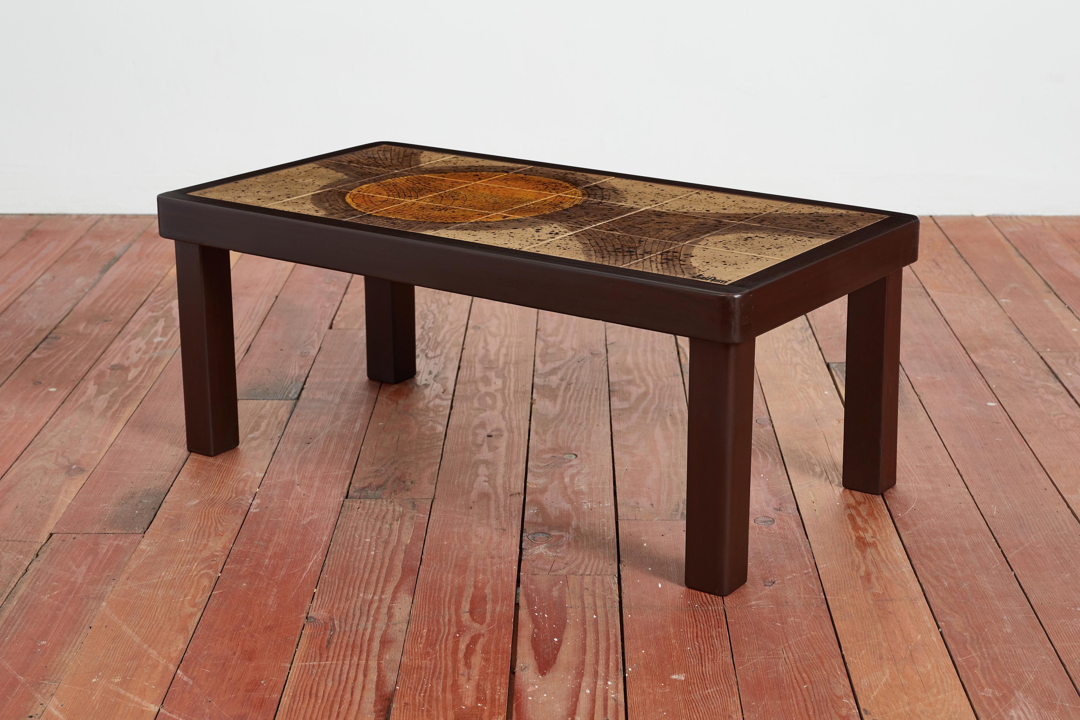 Wonderful coffee table by Jean d'Asti with ceramic tiles from Vallauris, France circa 1960's. Frame in elm wood that is newly refinished.  Rich natural colors of ceramic. 

Signature on tile. 

France, 1960s.

