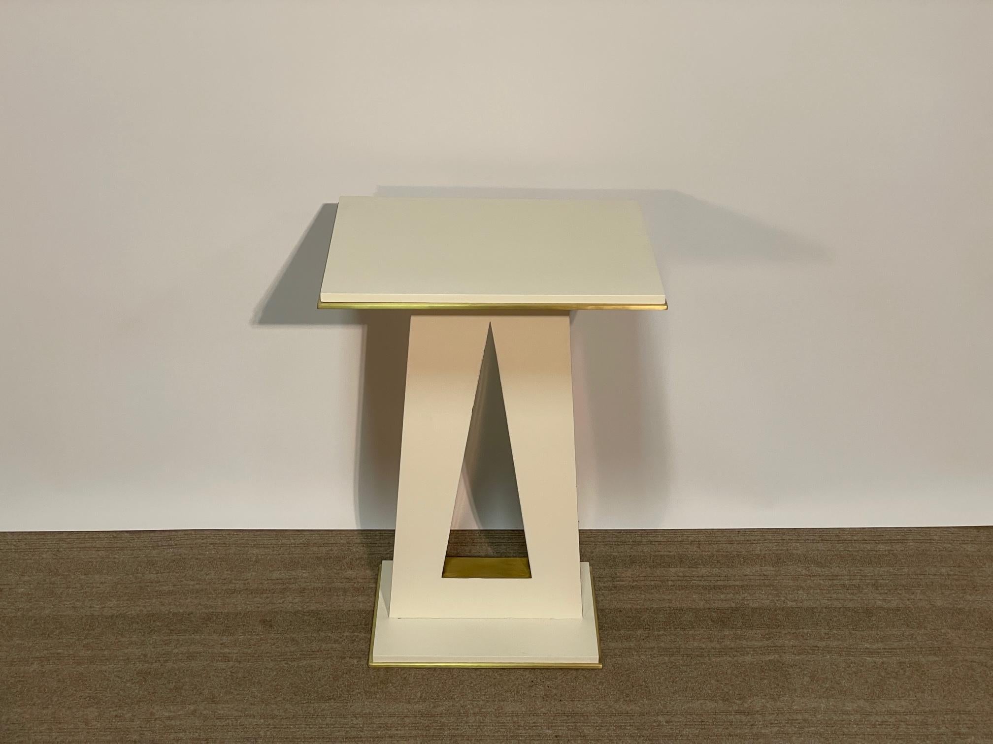 Jean de Merry's Api side table is composed of a wood frame with bronze accents on the base and top and inlay through the center design.  The frame and top are finished in Liso Satin and the bronze in JDM's Light Bronze.  Both tables are identical in