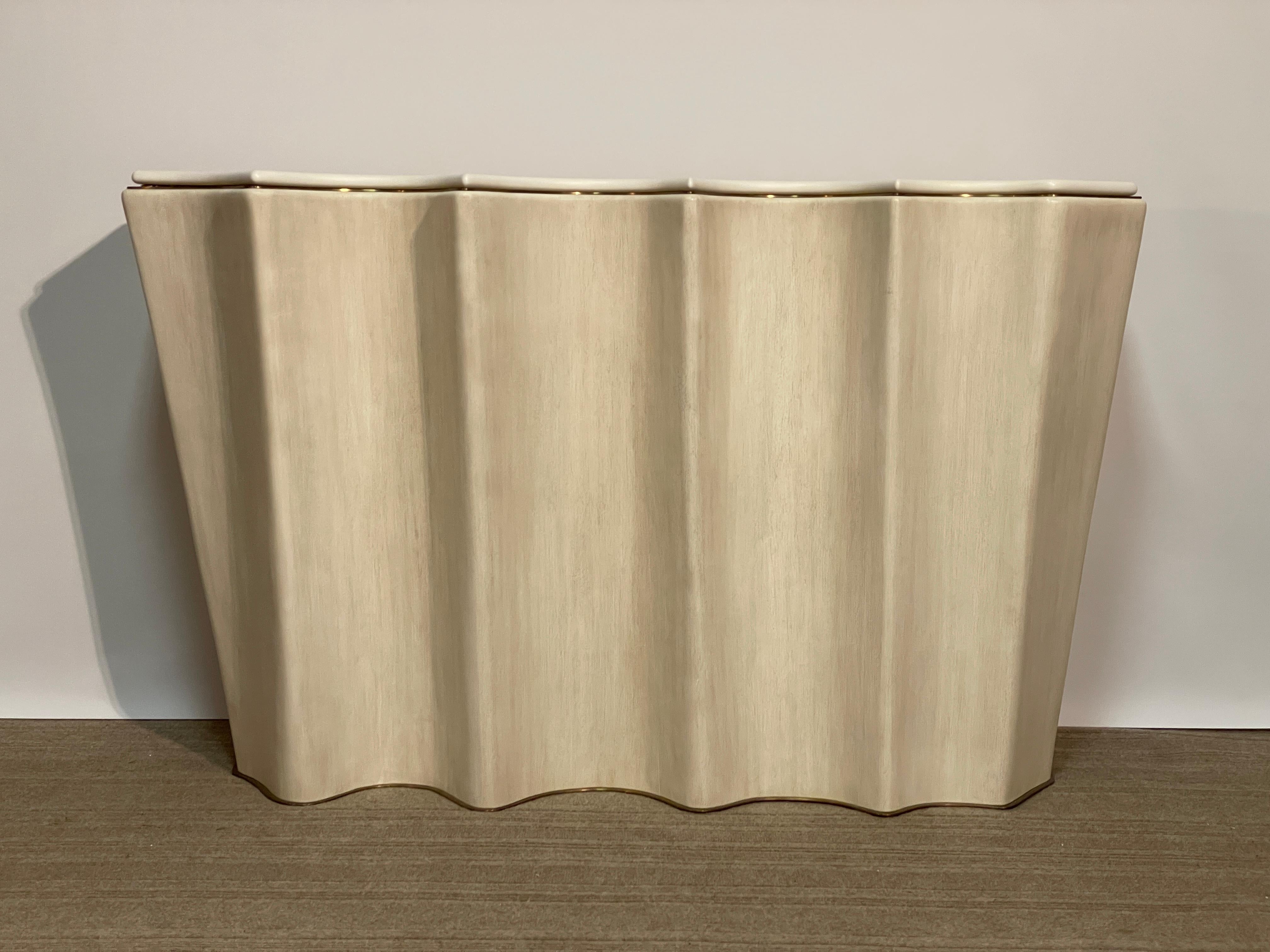 The Jean de Merry designed Ondula console waves inward with curvaceous beauty and outward with pointed forcefulness.  An organic shape that seems to flow from the wall itself uses the stated grandeur of its light bronze accents to affirm it's value