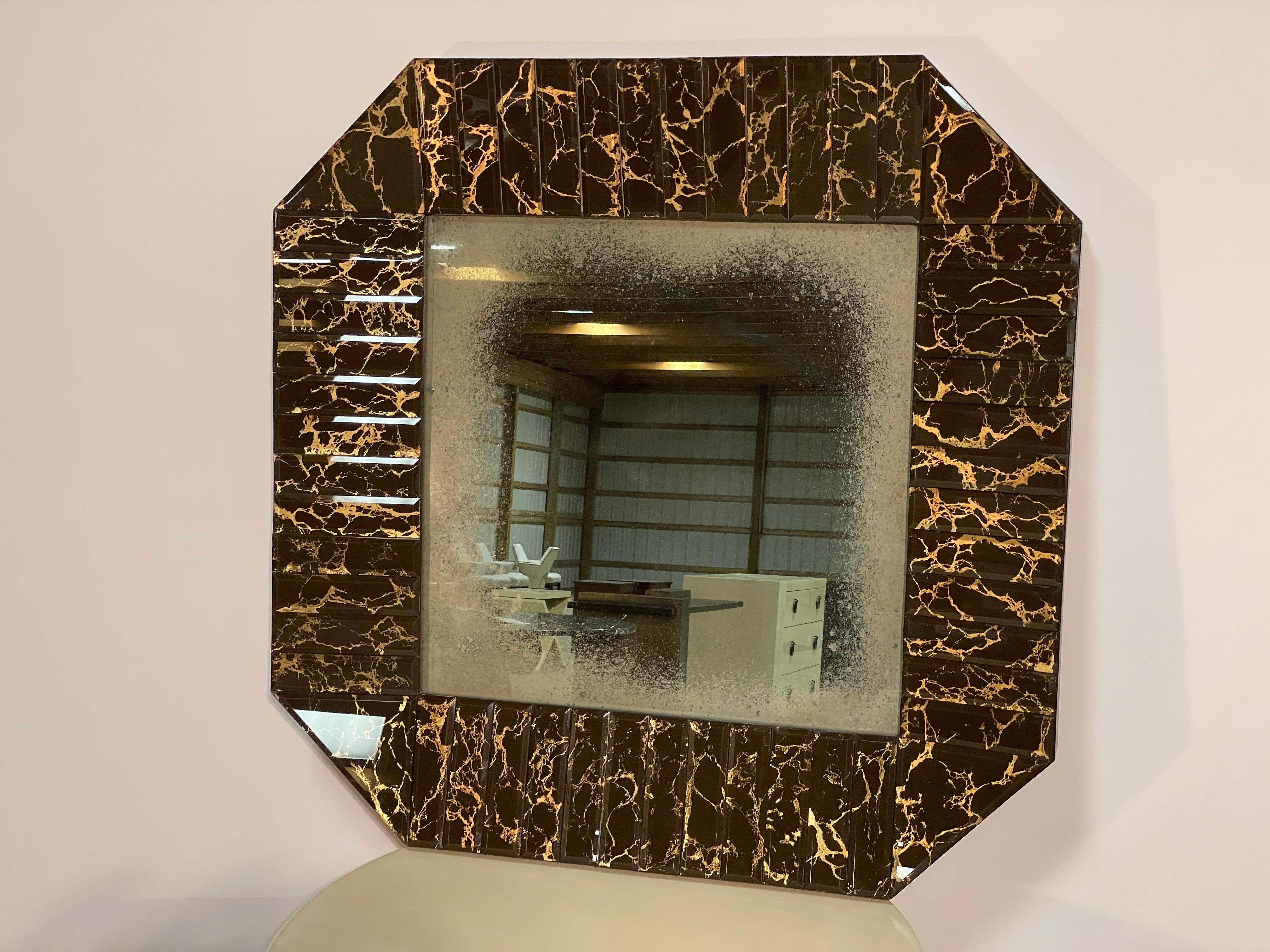 This Jean de Merry Veneto mirror showcases a plethora of individually beveled and reverse-glass painted baguettes surrounding an organically mercury aged mirror.  The Chocolate finish is luscious and moody, contrasted by the strikingly luxurious