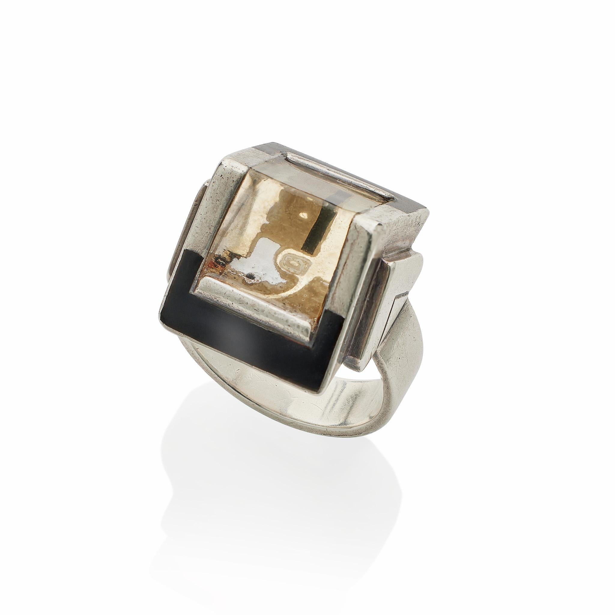 Composed of silver, lacquer and reverse painted and engraved crystal, this exceptional ring was a collaboration of two French modernist artists, Després and Cornault. The ring centers a glass crystal prism above a polychrome abstract-design painting