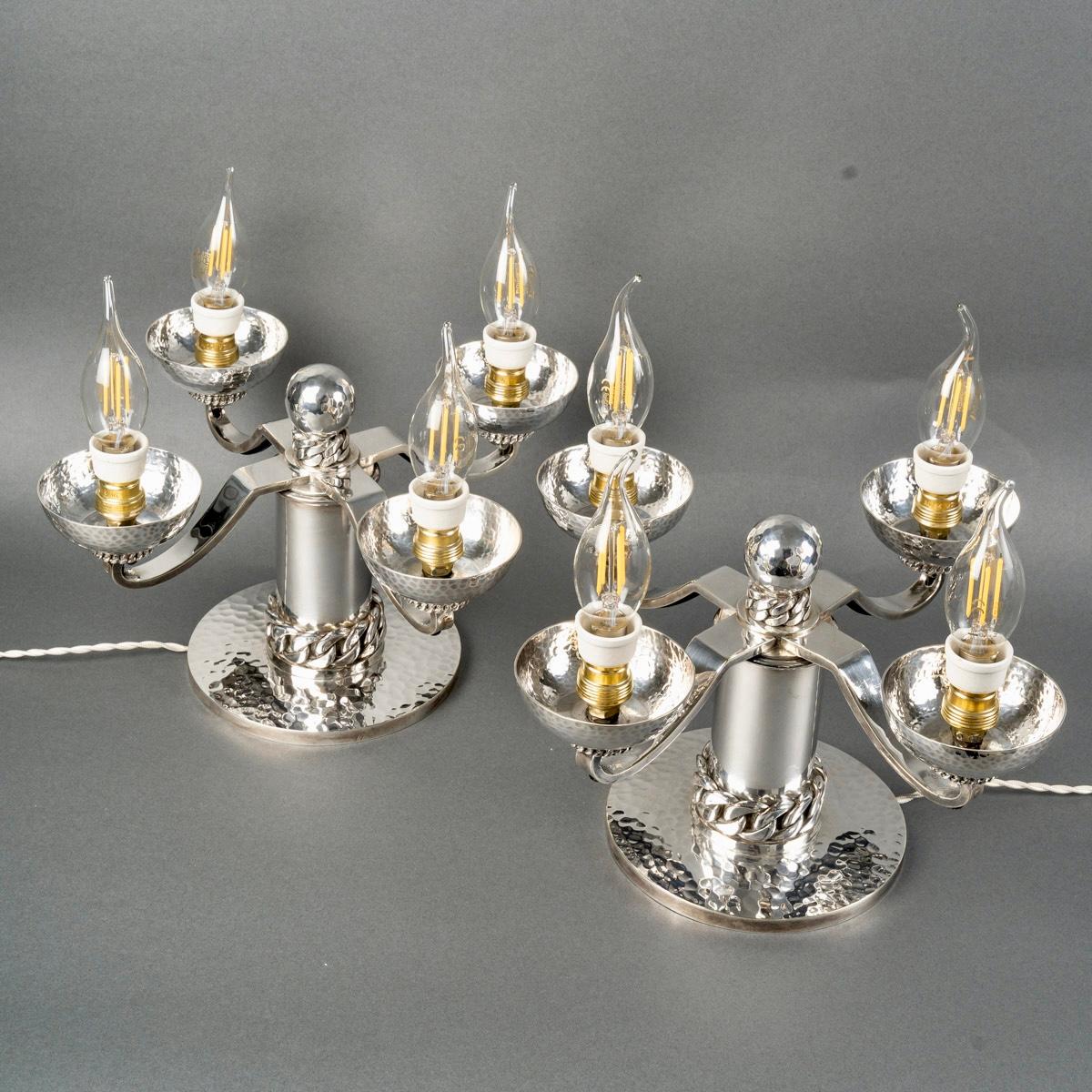 Pareja de candelabros Art Déco de metal plateado martillado y cadenas de Jean Desprès.
Firma grabada en ambas piezas.  
 
Magnífico estado. Modelo muy raro. 
Cableado nuevo. 

altura : 21 cm 
diámetro : 33 cm 