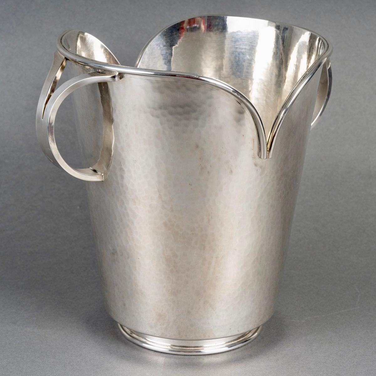 Cubitera de champán modernista Art Déco de metal plateado martillado de Jean Desprès.
Sello de Goldsmith en la base.

Magnífico estado. Modelo nunca visto.

Altura: 24 cm
Diámetro con asas: 24 cm
Diámetro sin asas: 21 cm