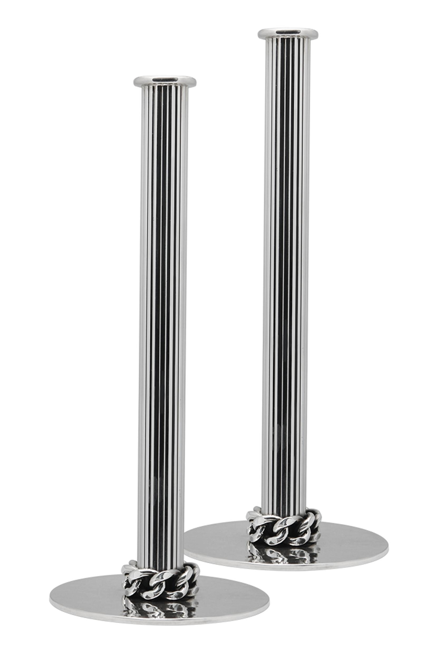 Jean Després pair of silvered metal candlesticks, signed J.Després, circa 1950. Each on flat base with hammered finish, iconic Després large curb link surround, columnar fluted stems. Measures: Height 24 cm.
