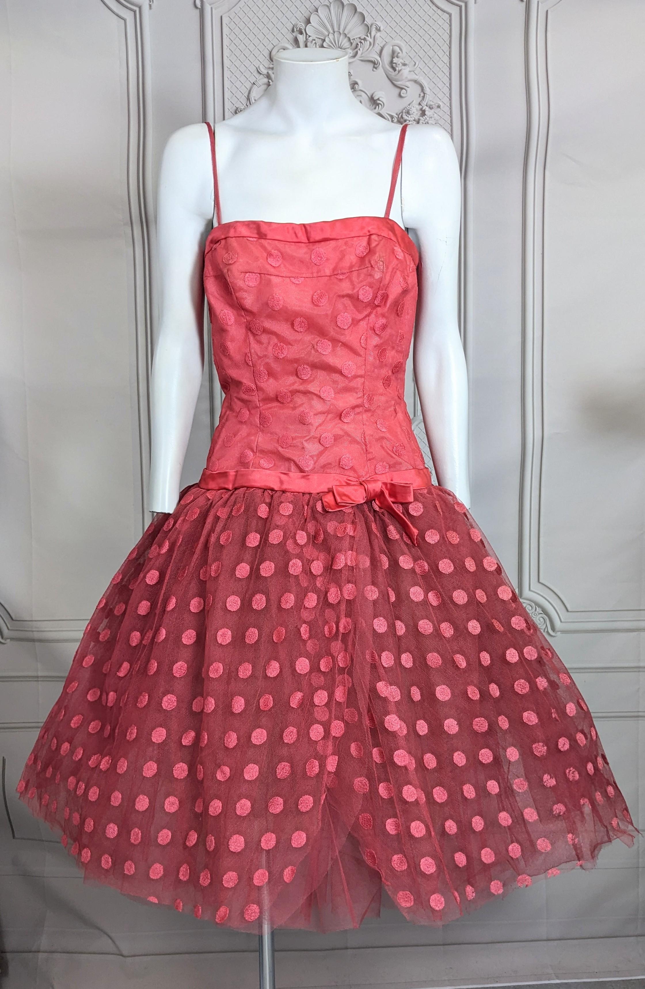 Charmantes Jean Desses Pret a Porter Point D'esprit Cocktailkleid aus Seide aus den 1950er Jahren. Tailliertes Mieder mit entbeintem Korsett aus gepunktetem Tüll über Taft mit Seidensatinbändern an Brust und Hüfte. Ein massiver Rock aus mehreren