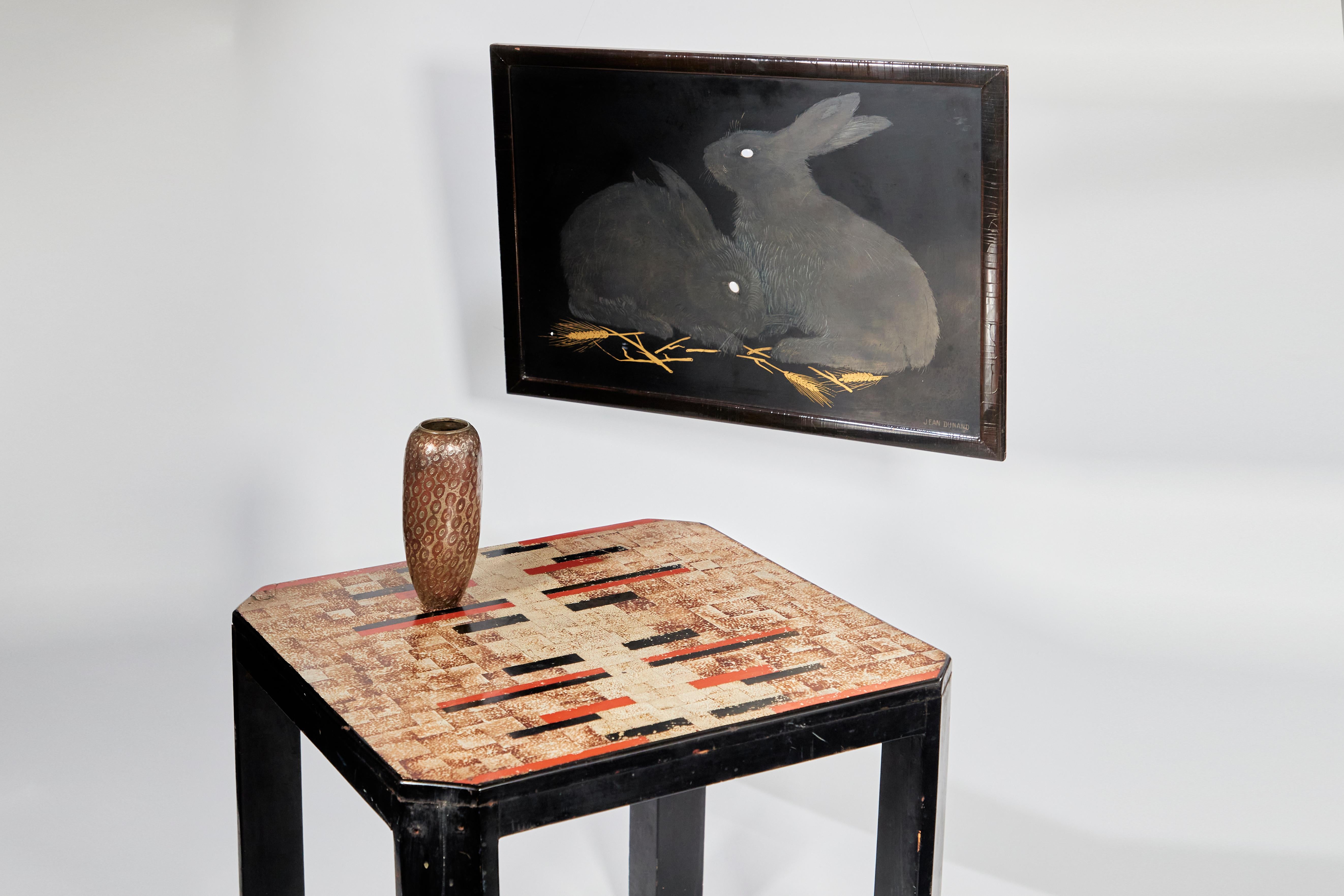 Square tope with crushed eggshell decoration, resting on four angled legs of triangular section in black Chinese lacquer. Original condition. Signed 