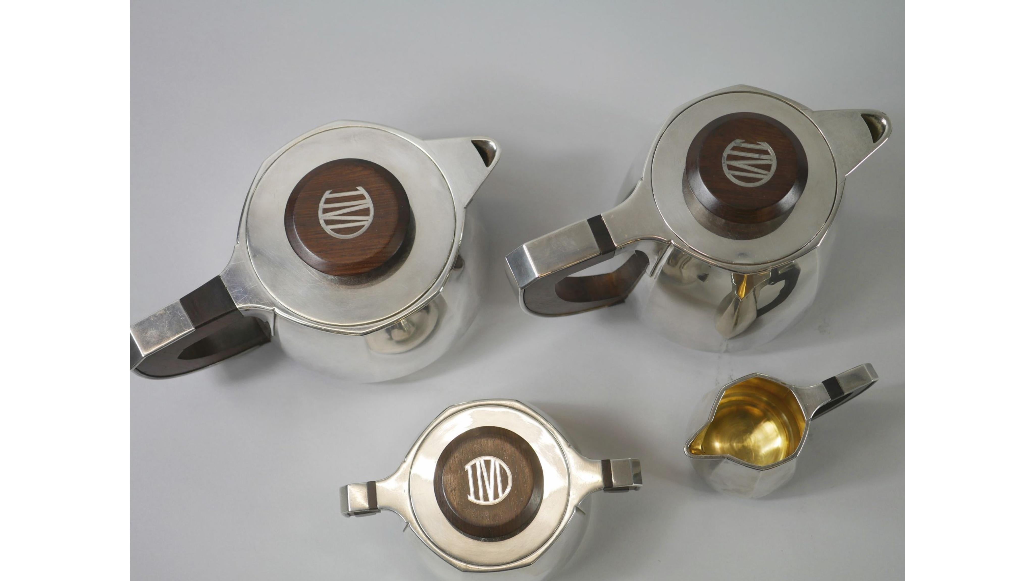 Jean-Emile Puiforcat (1897-1945) (Jean-elisée Puiforcat, Dit).
Tea and coffee service of four pieces in plain silver with cut sides on a small foot. The handles, holds and lids in rosewood sheathed in silver.
Including four pieces of forms: a
